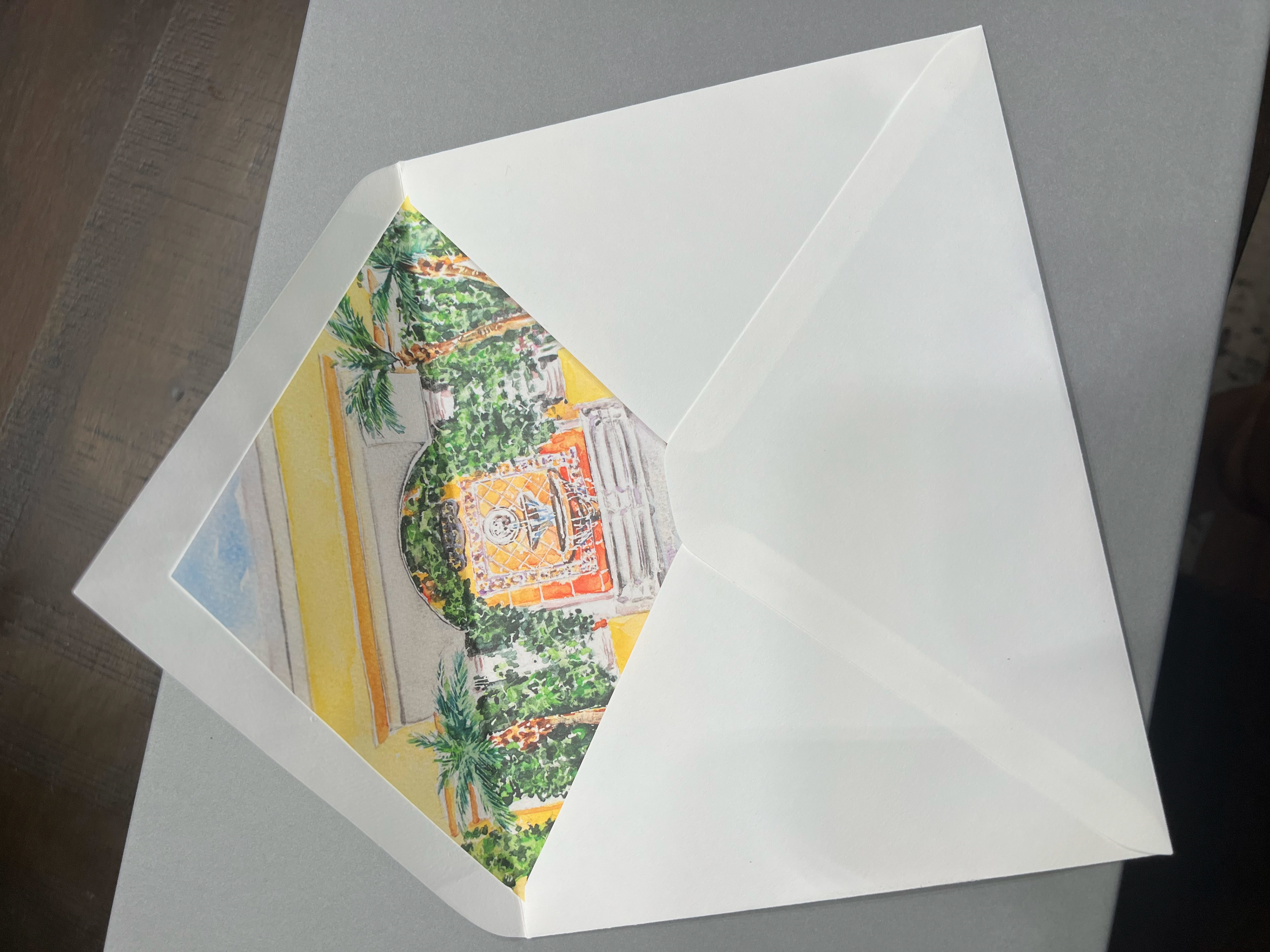 A sample of a custom envelope liner with a watercolor venue illustration depicting Benvenuto Restaurant in Florida