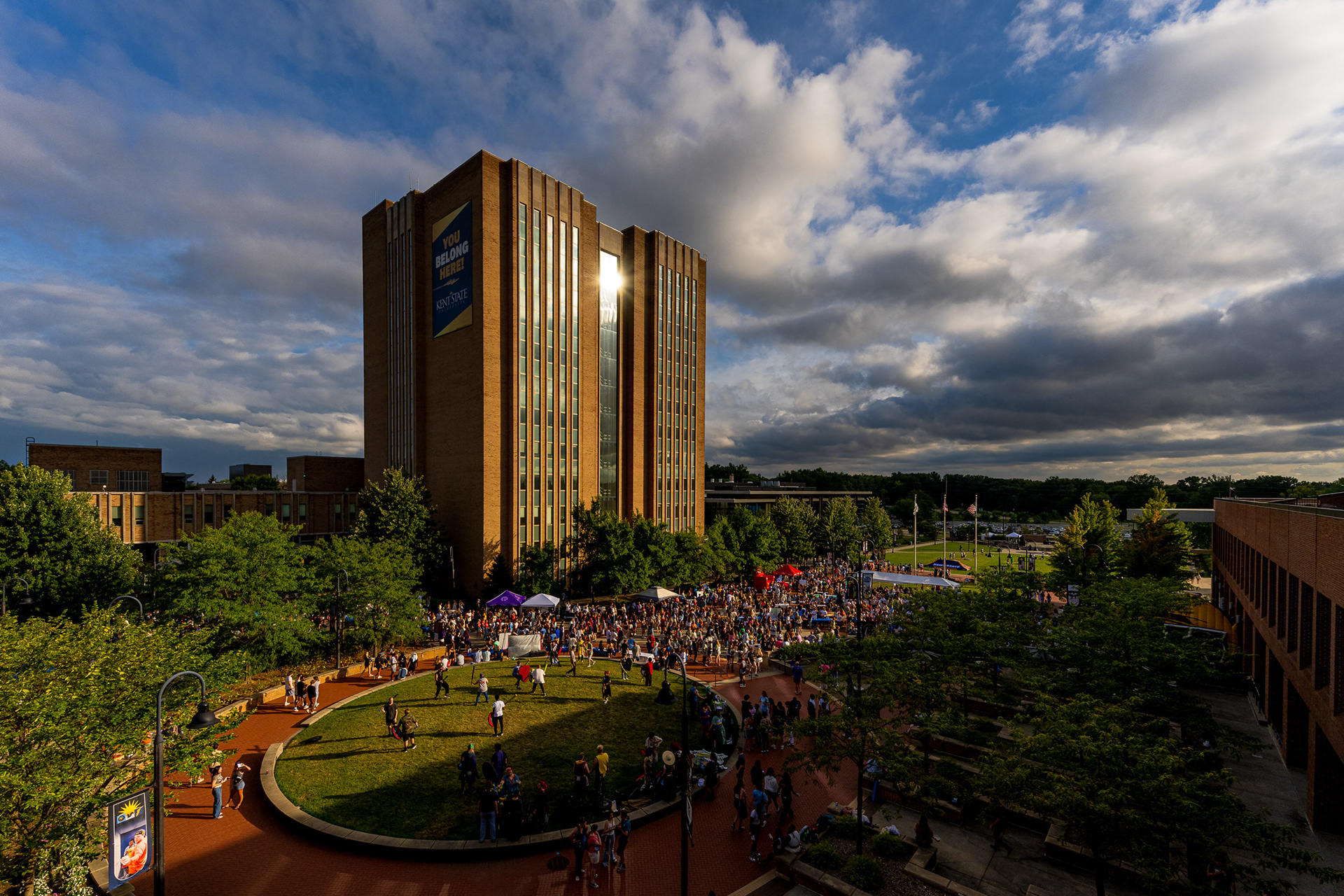 Students gather on Risman Plaza as the sun sets behind the Kent State Library.