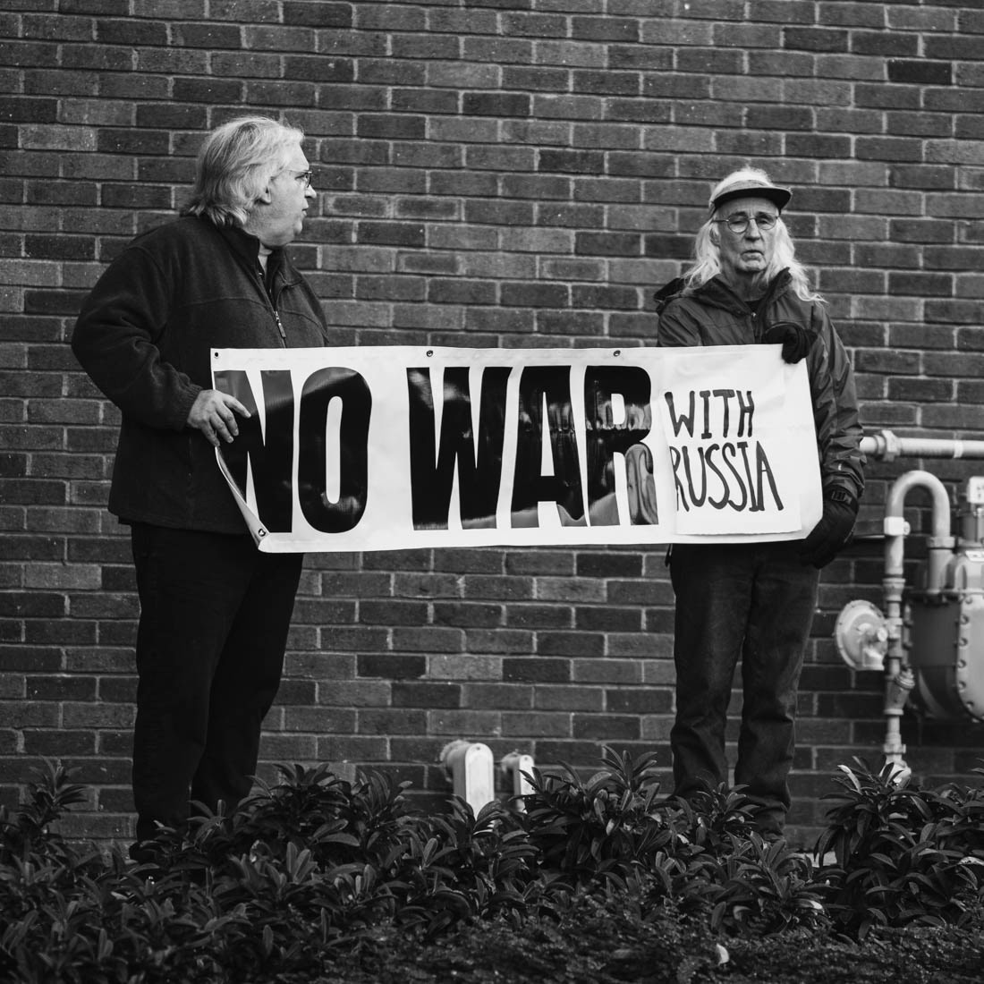 Two crowd members hold up a sign in protest of the ongoing conflicts occurring within Russia, a conflict that has escalated into a siege on Ukraine and hinted towards the possibility of war with other nations. Vermont Senator Bernie Sanders joined Oregon’s Democratic party leaders at the University of Oregon’s Erb Memorial Union for a rally in support of Oregon Democrat Gubernatorial candidate Tina Kotek, on Thursday, Oct., 27th, 2022. (Maddie Stellingwerf/ Emerald)