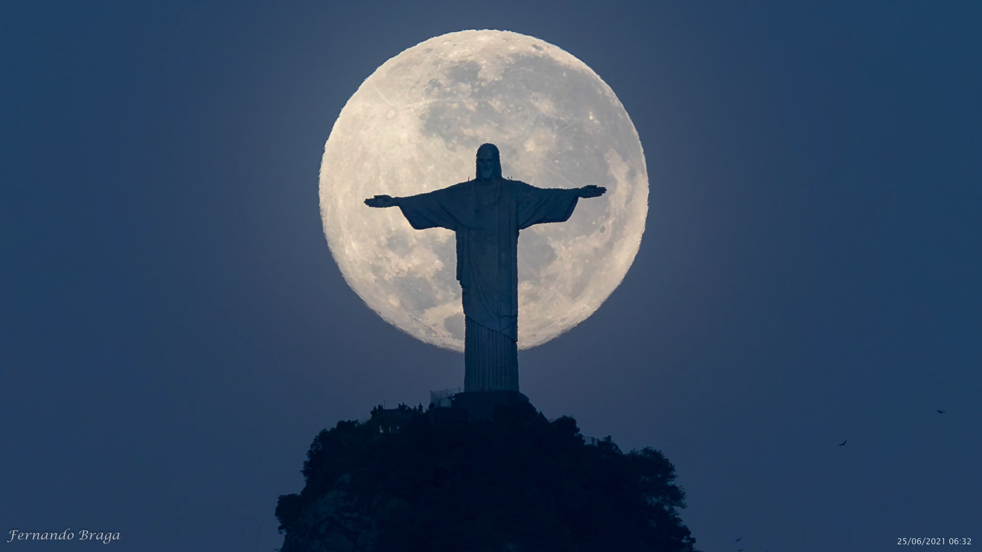 Encontro da última super lua de 2021 cravando seu centro na cabeça do Cristo Redentor ao nascer do sol, registrada da minha casa no bairro do Flamengo, Rio de Janeiro/RJ, Brasil.
