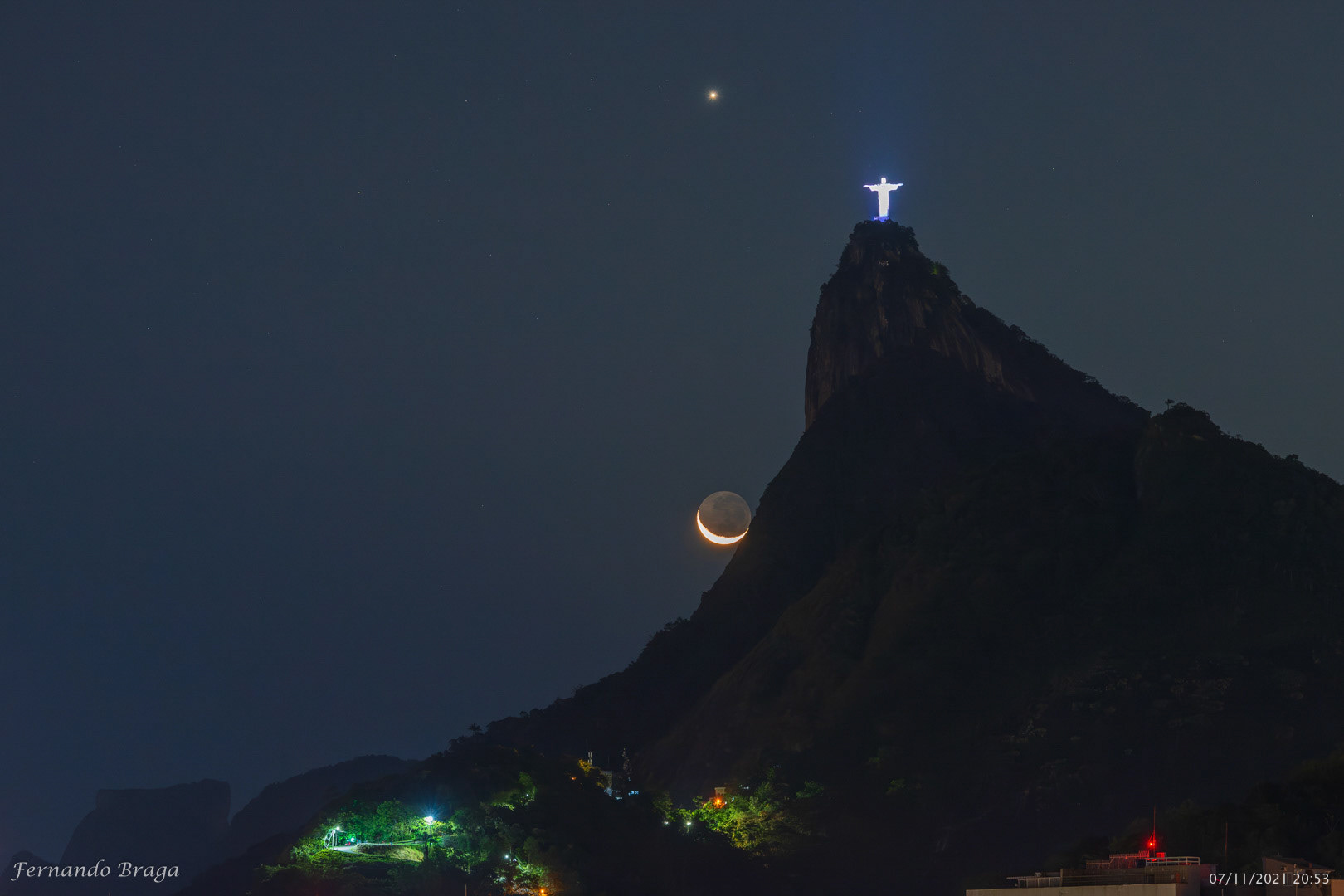 Um encontro celestial entre o planeta Vênus, a Lua Crescente e o Cristo Redentor.
