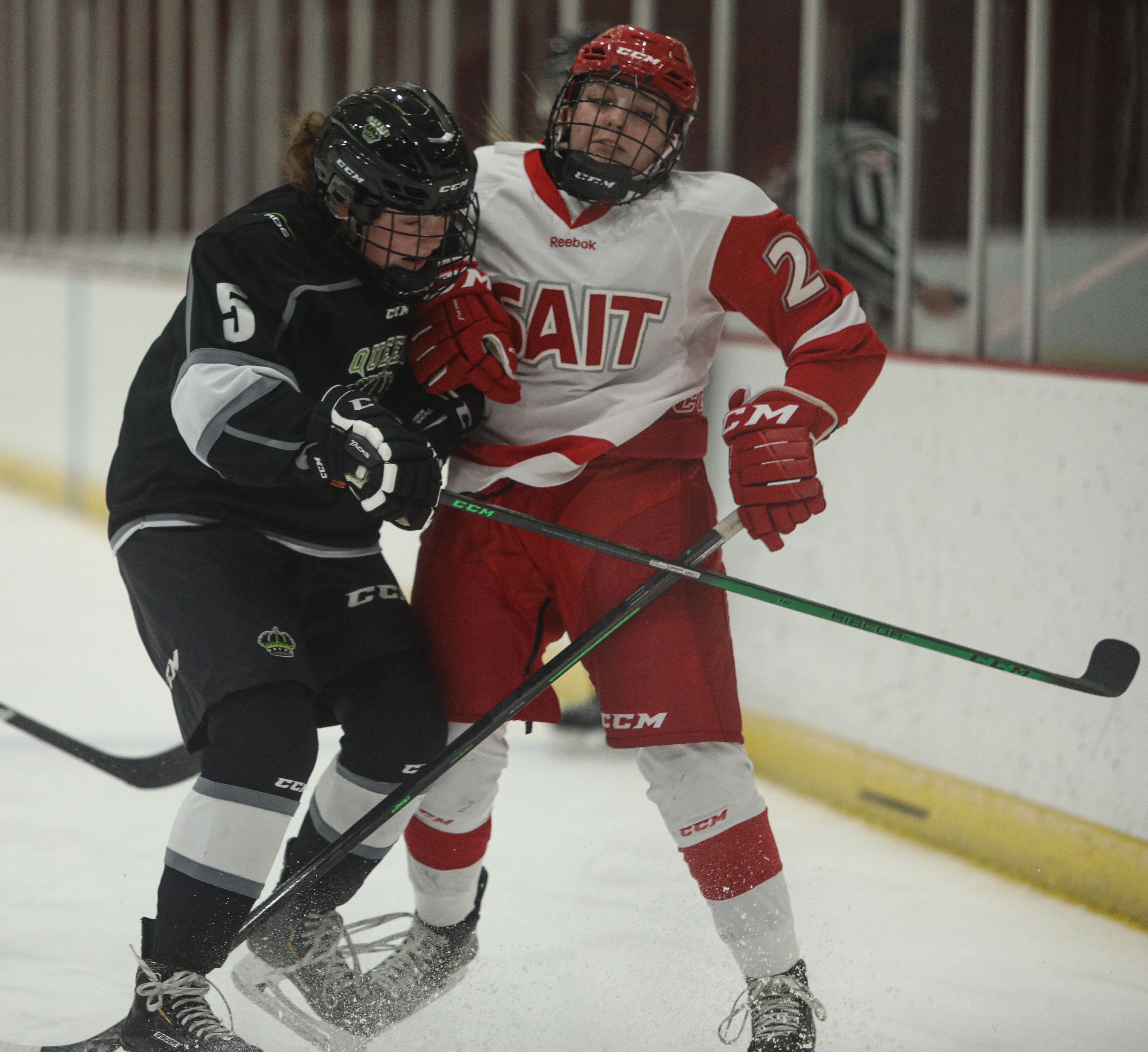 SAIT Trojans forward Pyper Alexander and Red deer player fight during a hockey game at the SAIT arena.