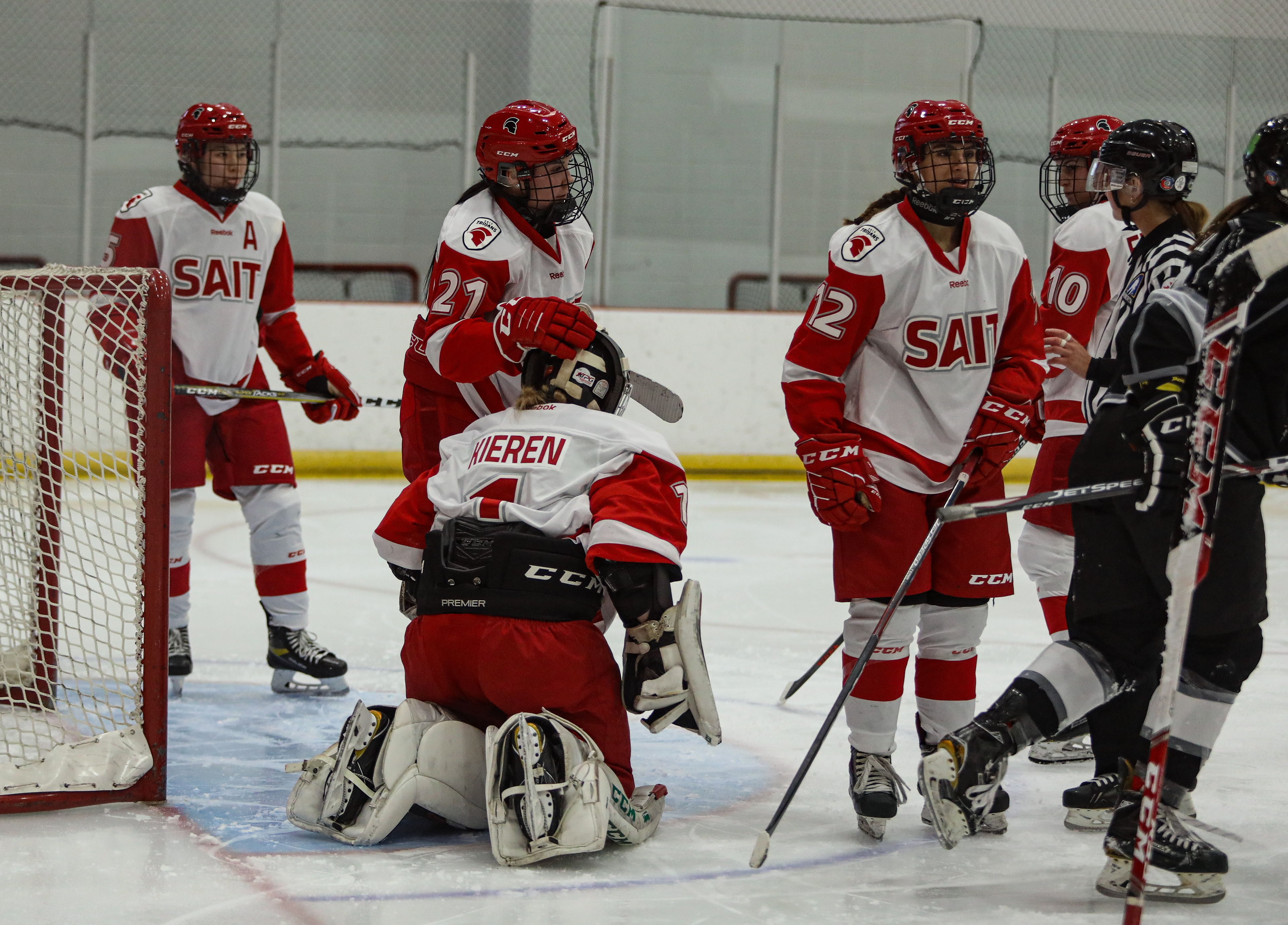 SAIT Trojans forward Reauna Blight comforts goalie Ali Kieren during a hockey game at the SAIT arena.