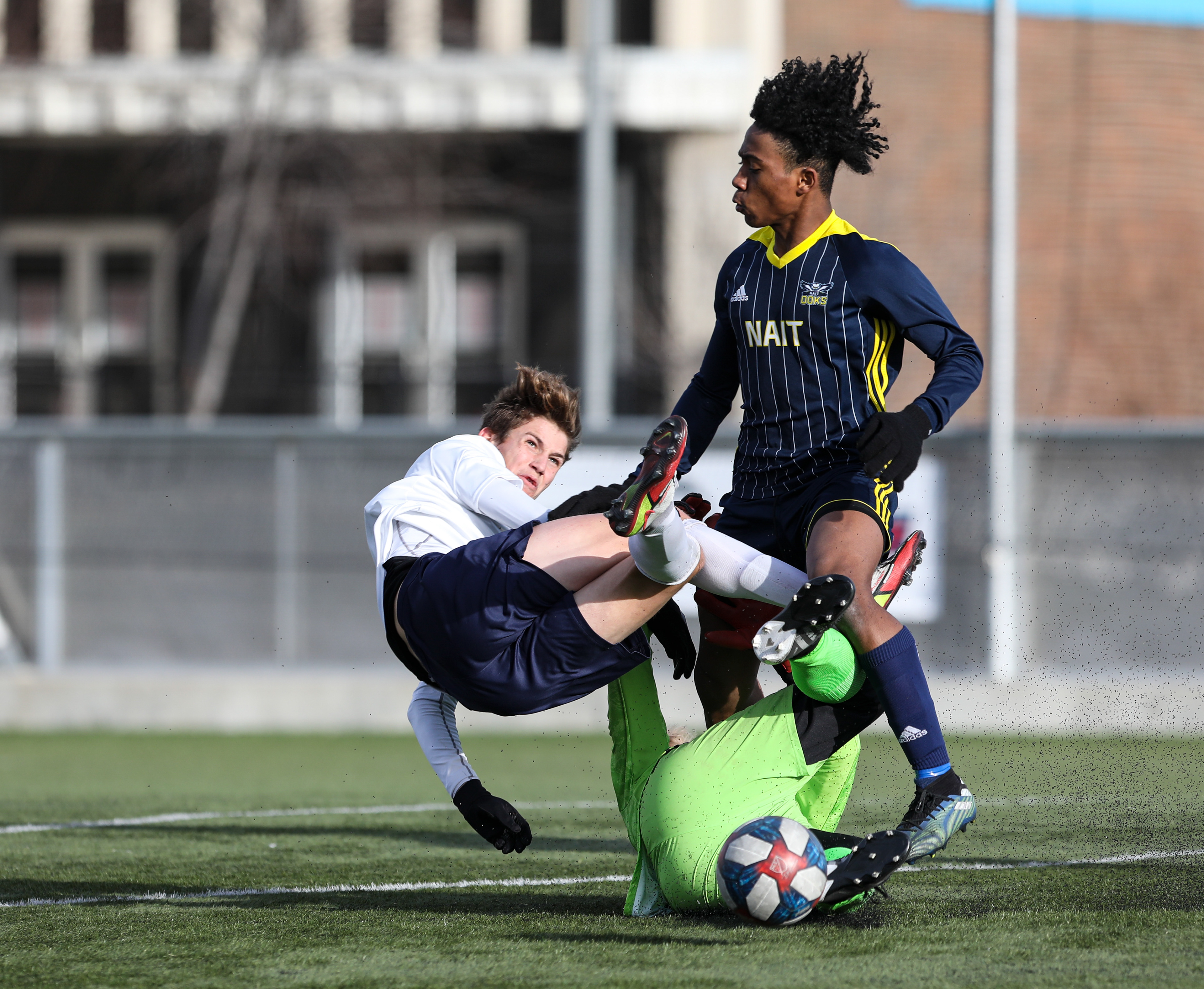 The NAIT Ooks player and the Montmorency College Nomades players fall down in men’s soccer action.