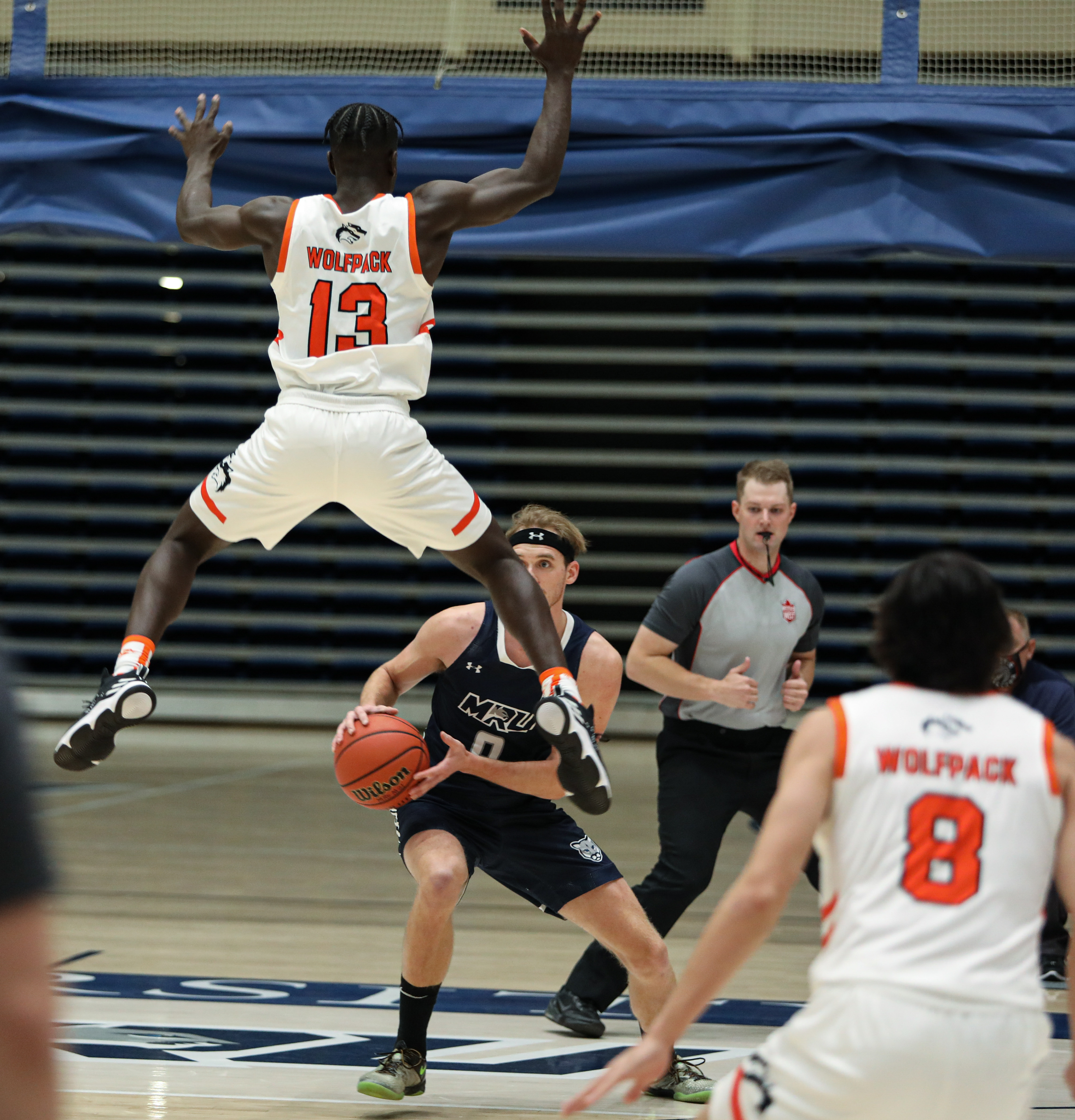 Thompson Rivers University Wolfpack guard Richie Mageto, left, jumps to prevent Mount Royal University Cougars forward Dylan Lutes, right, Wolfpack at the Mount Royal gymnasium in Calgary on Friday, Oct. 15, 2021. The Cougars beat the Wolfpack by a score of 67-66 in Alberta Colleges Athletic Conference men’s basketball action.