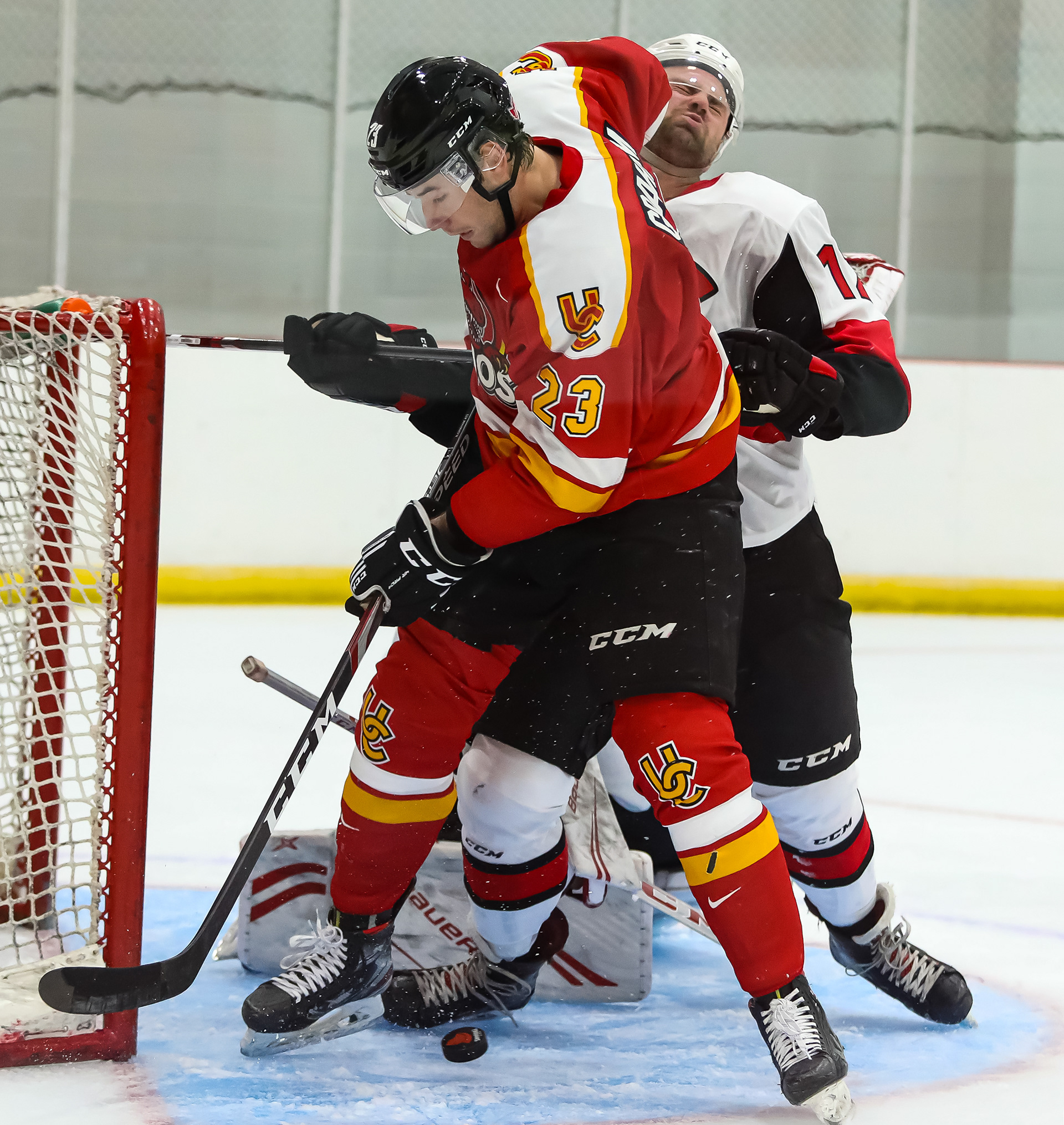 SAIT Trojans player and University of Calgary Dinos player fight in front of the goal post during a hockey game at the SAIT arena in Calgary on Wednesday, Sept. 15, 2021. The U of C Dinos defeated the Trojans, 8-1.