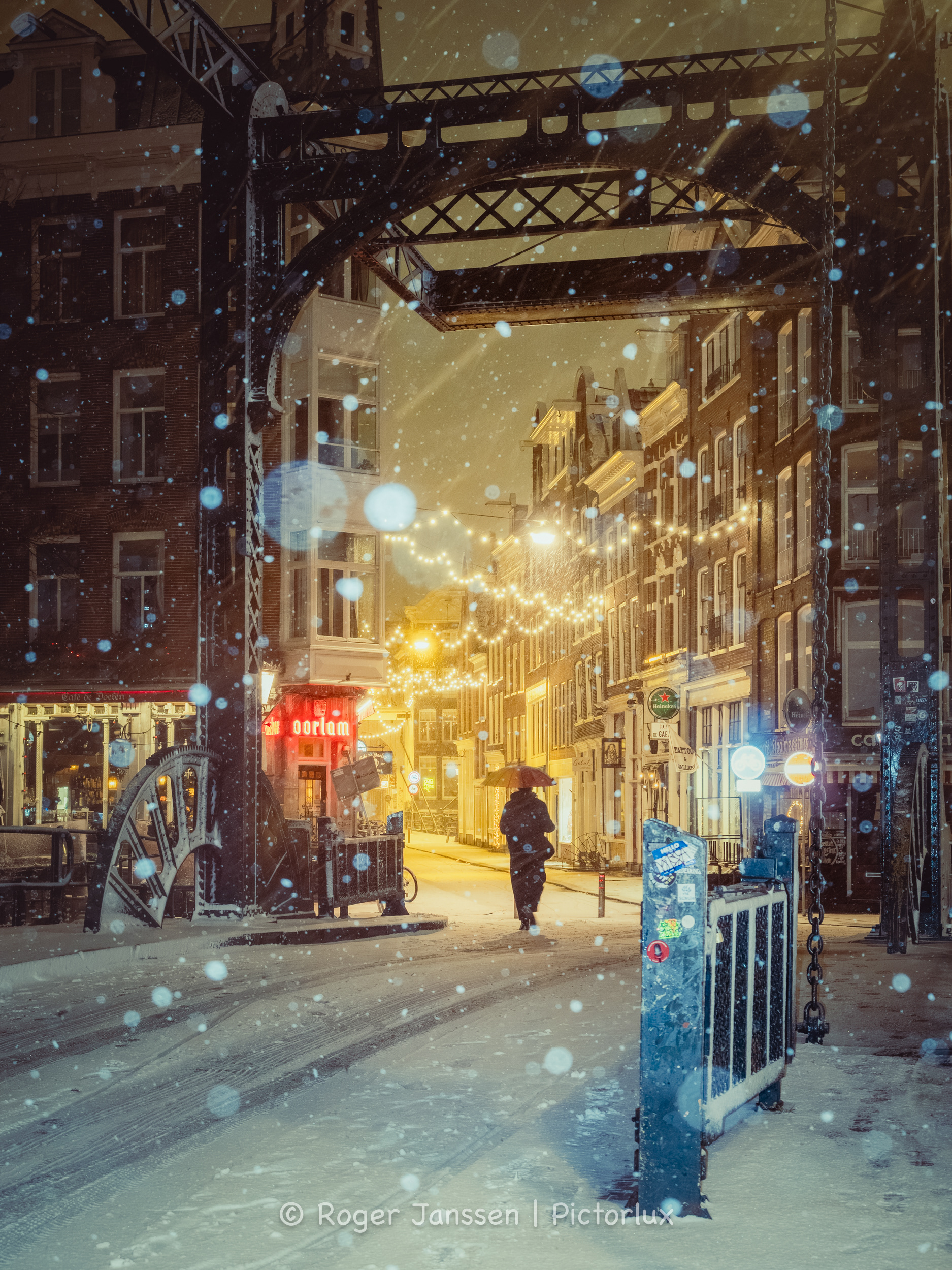 Lone walker during a blizzard crossing the Aluminum Bridge near Café de Doelen in Amsterdam.