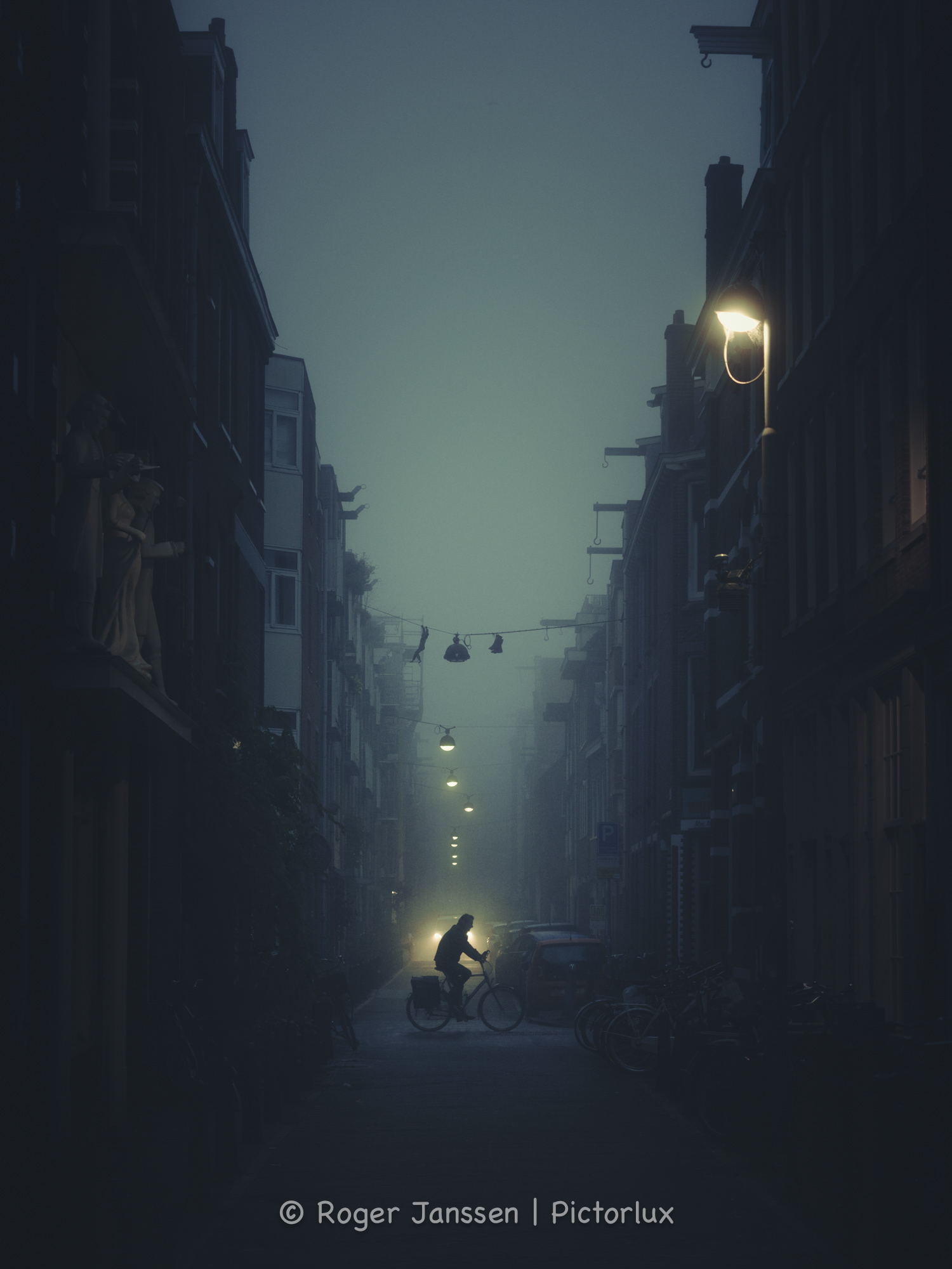 Cyclist crossing the streets in the Jordaan in Amsterdam on a foggy winter morning.