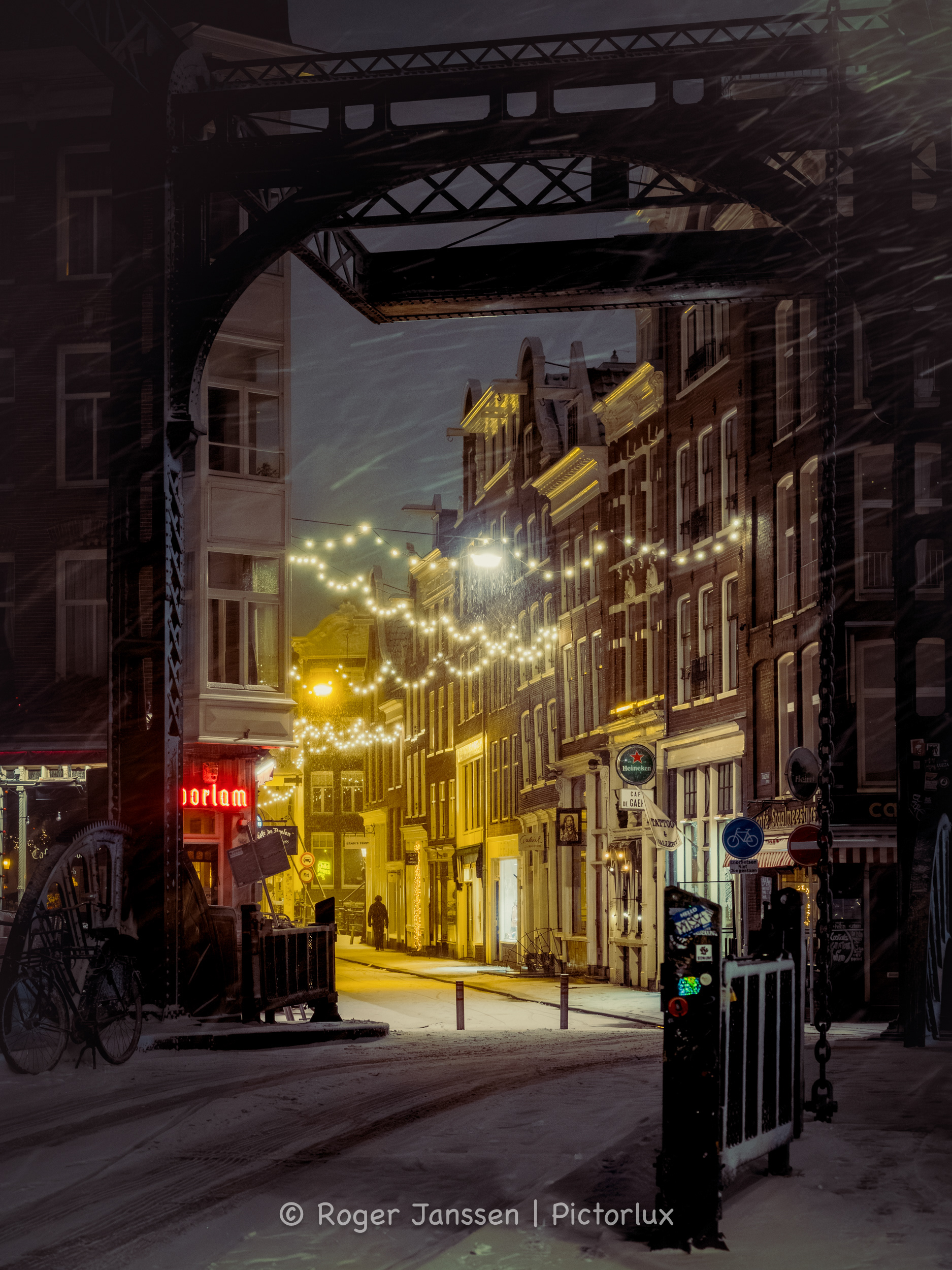 Aluminiumbrug, De Staalstraat, Café de doelen, en een eenzame wandelaar in de sneeuwjacht in Amsterdam.