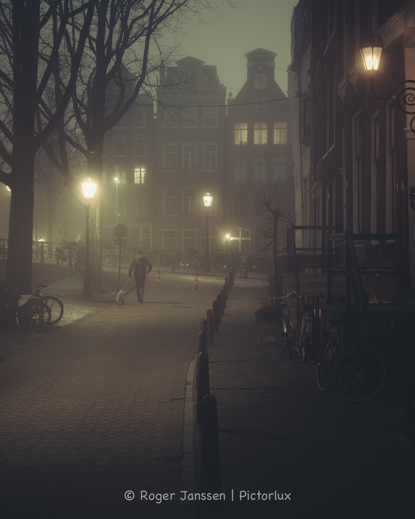 Early morning dogwalker on the Brouwersgracht in Amsterdam on a foggy morning.