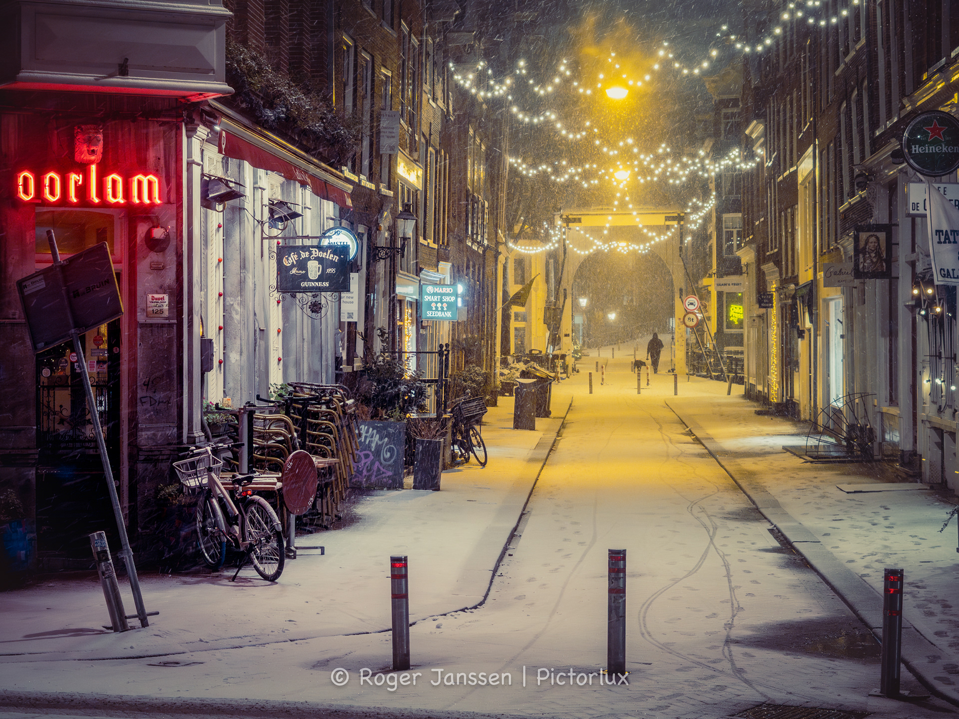 Lone pedestrian on the Staalmeestersbrug during a blizzard in Amsterdam.