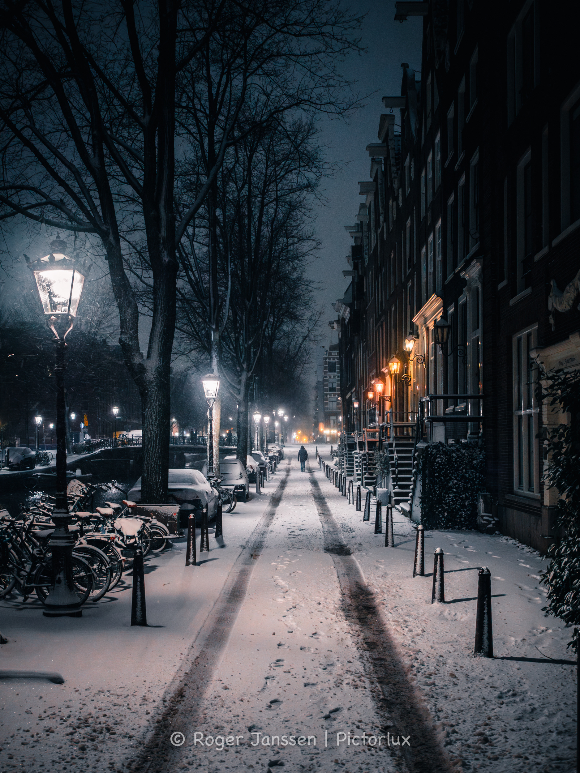 Eenzame wandelaar in de sneeuw op de Leidsegracht in Amsterdam.