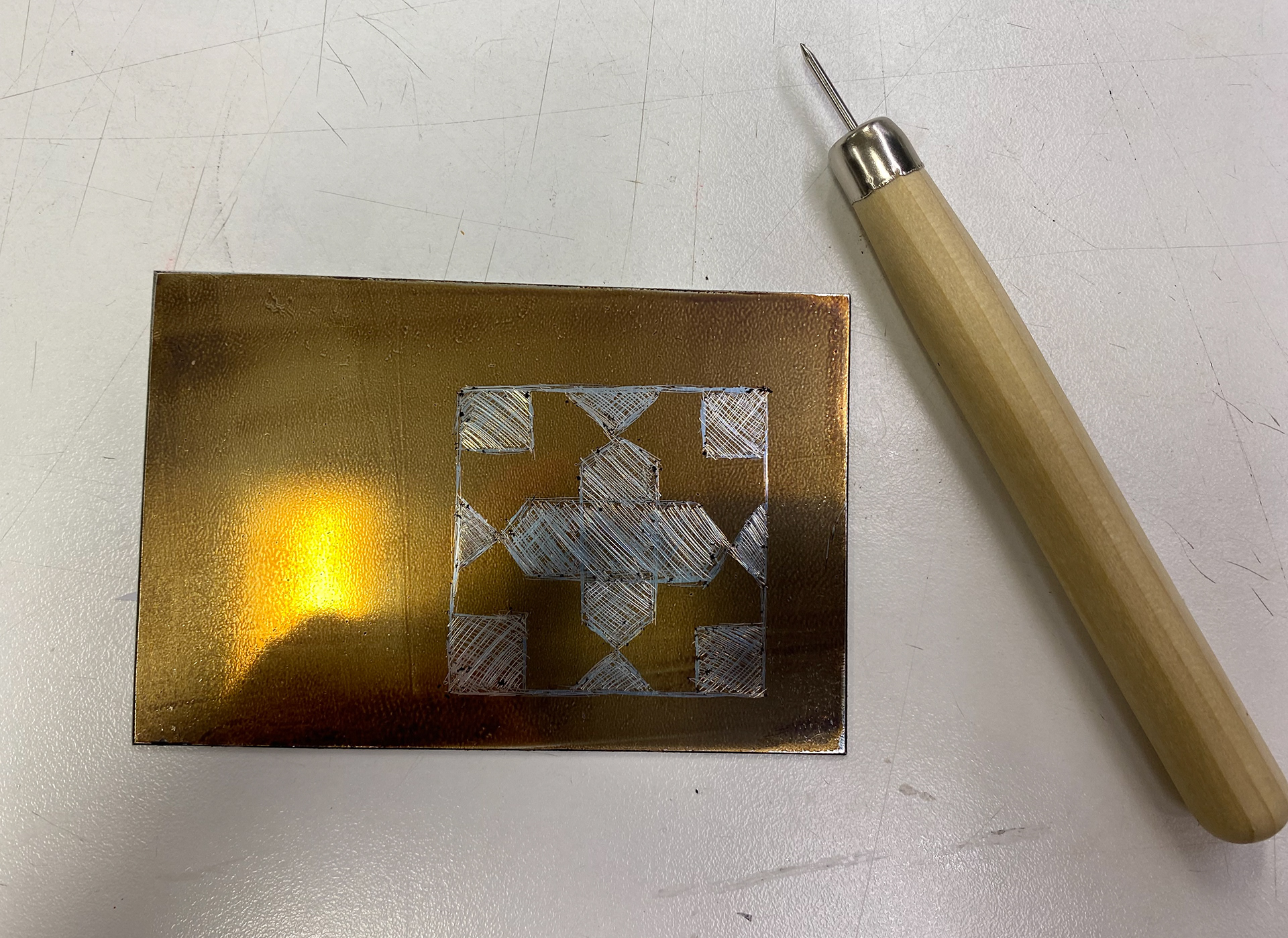 Metal prepared, ground applied and pattern etched.