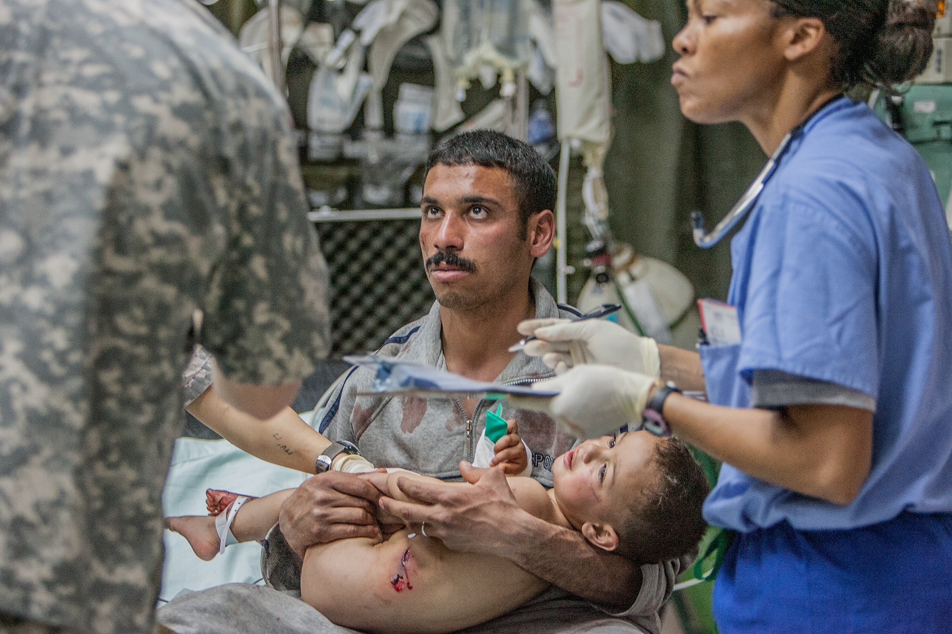 A three year old Iraqi boy held by his father. Two families were struck by a mortar in western Baghdad, and brought to the hospital by American soldiers who were nearby during the attack.