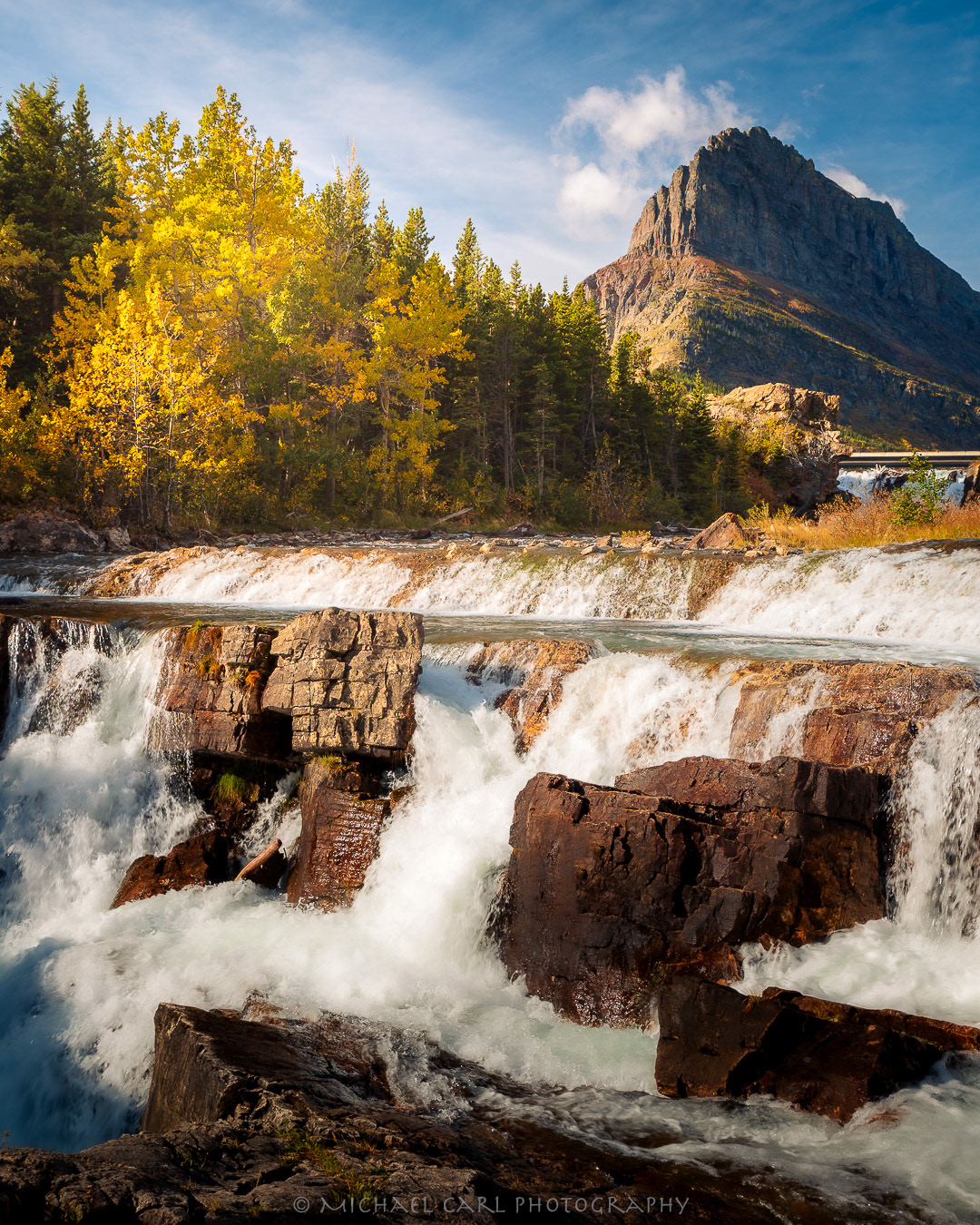 Glacier National Park landscape photography of Swiftcurrent Falls with Grinnell Point in background.