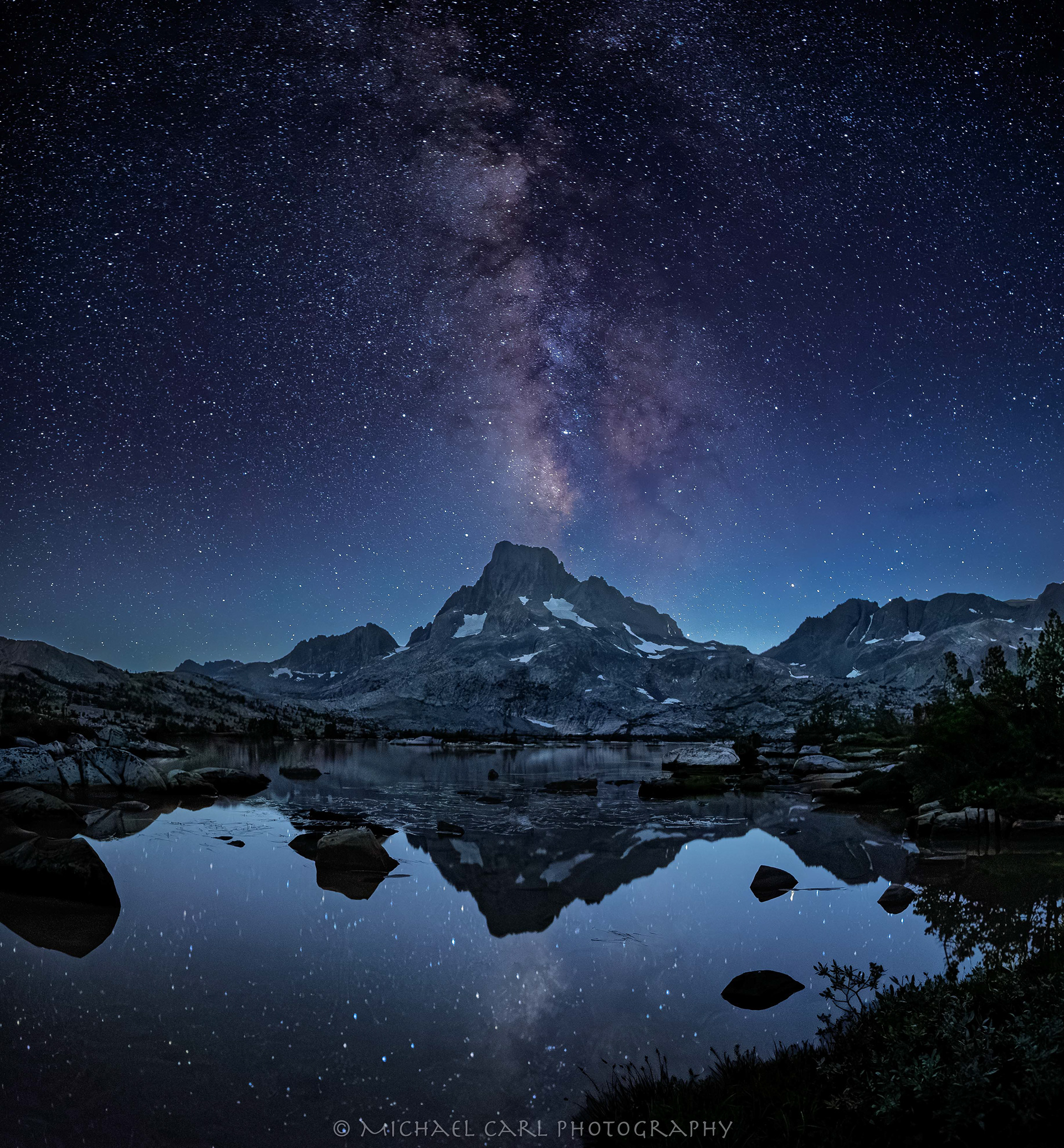 Night sky photography of Milky Way over Banner Peak in Sierra Nevada Mountains.
