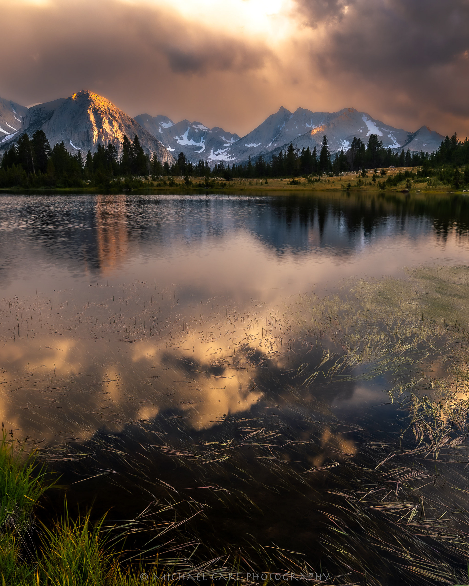 Sierra Nevada landscape photography of lake reflection of sun and clouds.