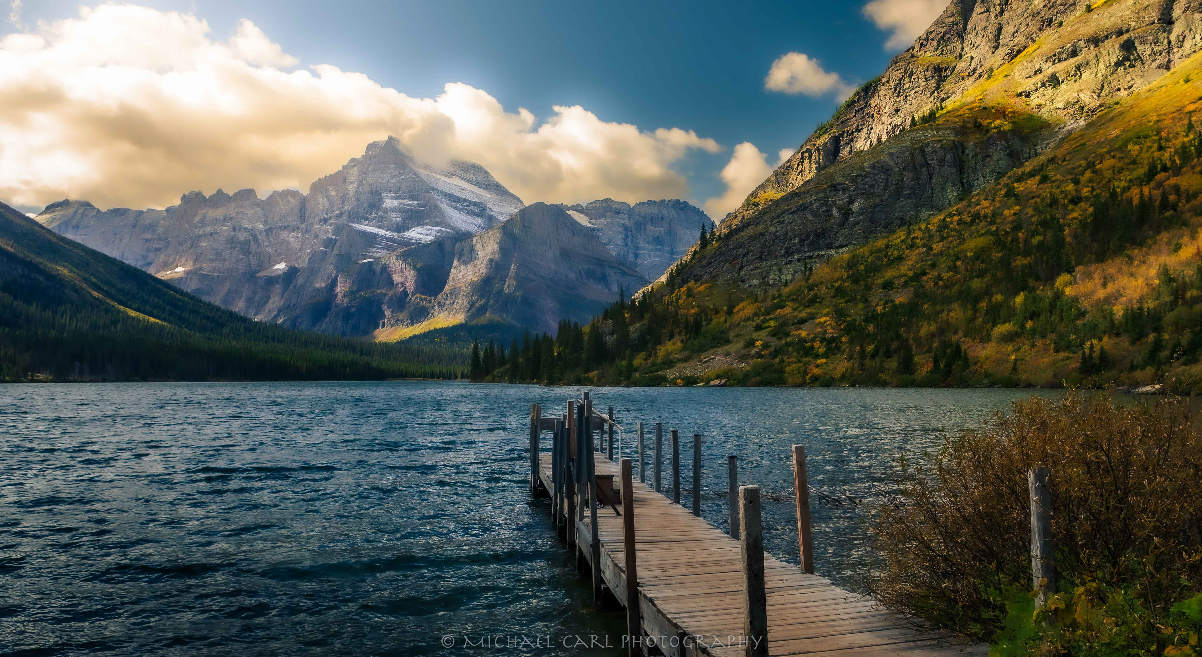 Montana Rocky Mountains photography in Glacier National Park as sun spotlights Lake Josephine, Mount Gould, Allen Mountain, and the Angel Wing.