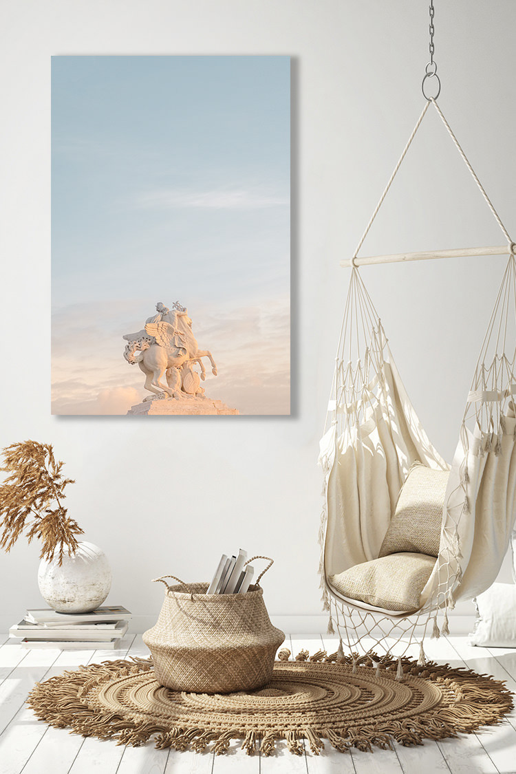 Une photographie épurée aux tons pastels représentant une statue de l’entrée du Jardin des Tuileries à Paris. La scène portée vers le ciel invite à une sensation de liberté. Les couleurs douces et pastel du coucher du soleil et le voile nuageux offrent légèreté et douceur.  Statue “Mercure chevauchant Pegase” de l’artiste Antoine Coysevox.   Localisation : Paris, France.