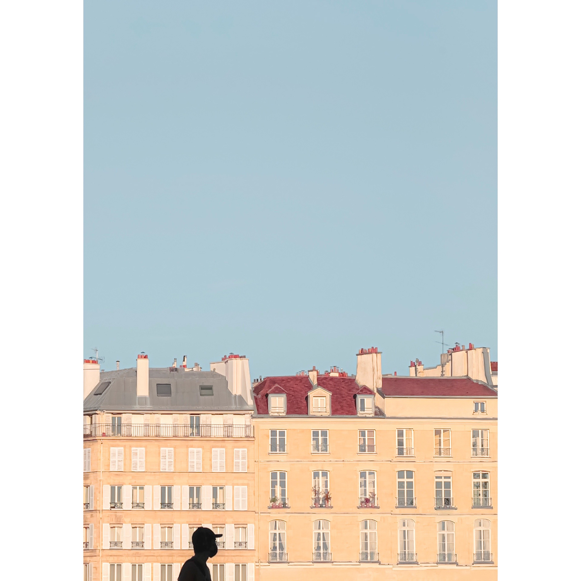 Tiny silhouette in front of a facade with a typical parisian architecture. Minimal and inspiring street photography look. 2021, Paris, France 