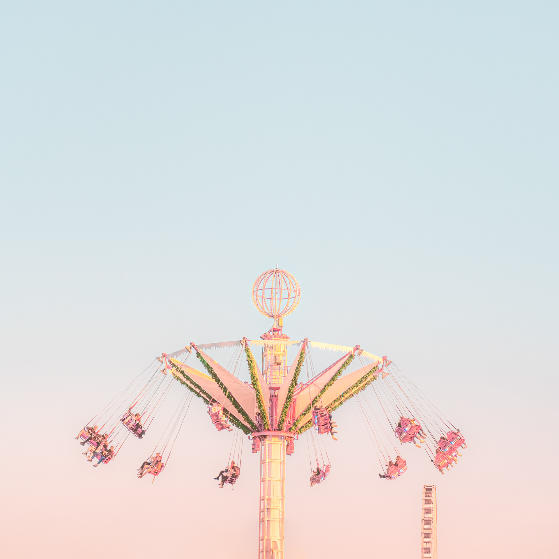 The carousel of the fun fair of Paris, in the Tuileries Gardens, on a blurred pastel sky at sunset. Pink to blue gradient of colors. Paris