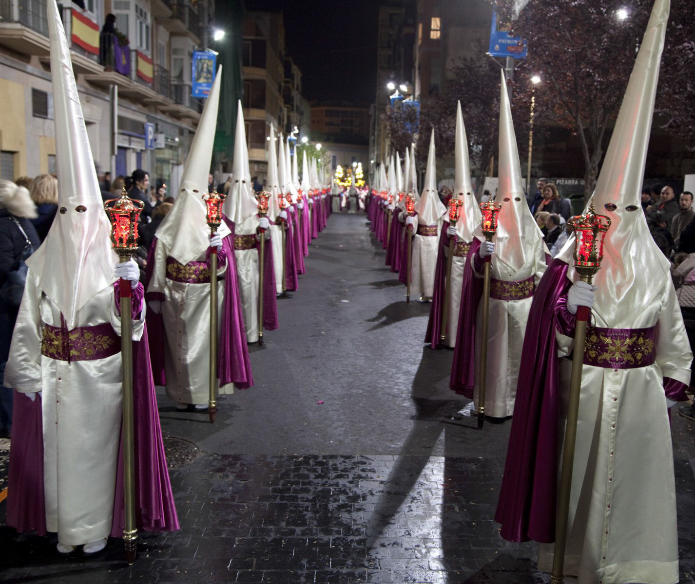 Nazarenos in a night time procession during Semana Santa (Holy Week) in Cartagena, Spain