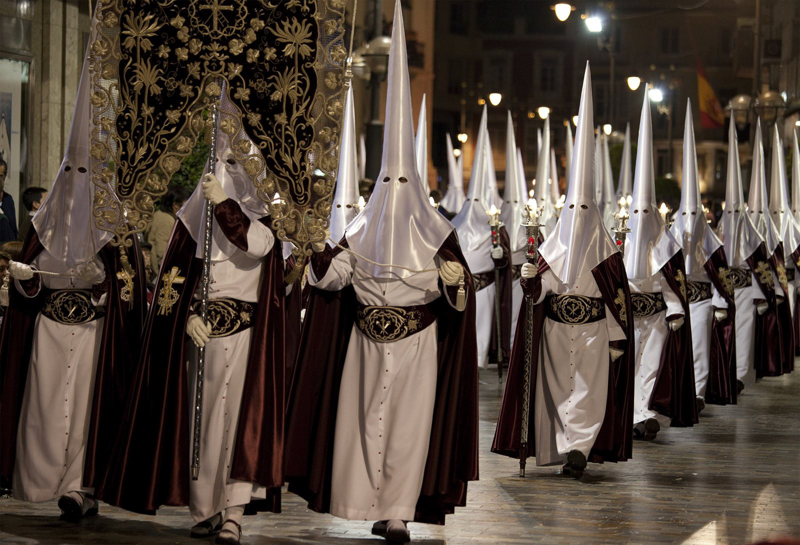 Nazarenos in a night time procession during Semana Santa (Holy Week) in Cartagena, Spain