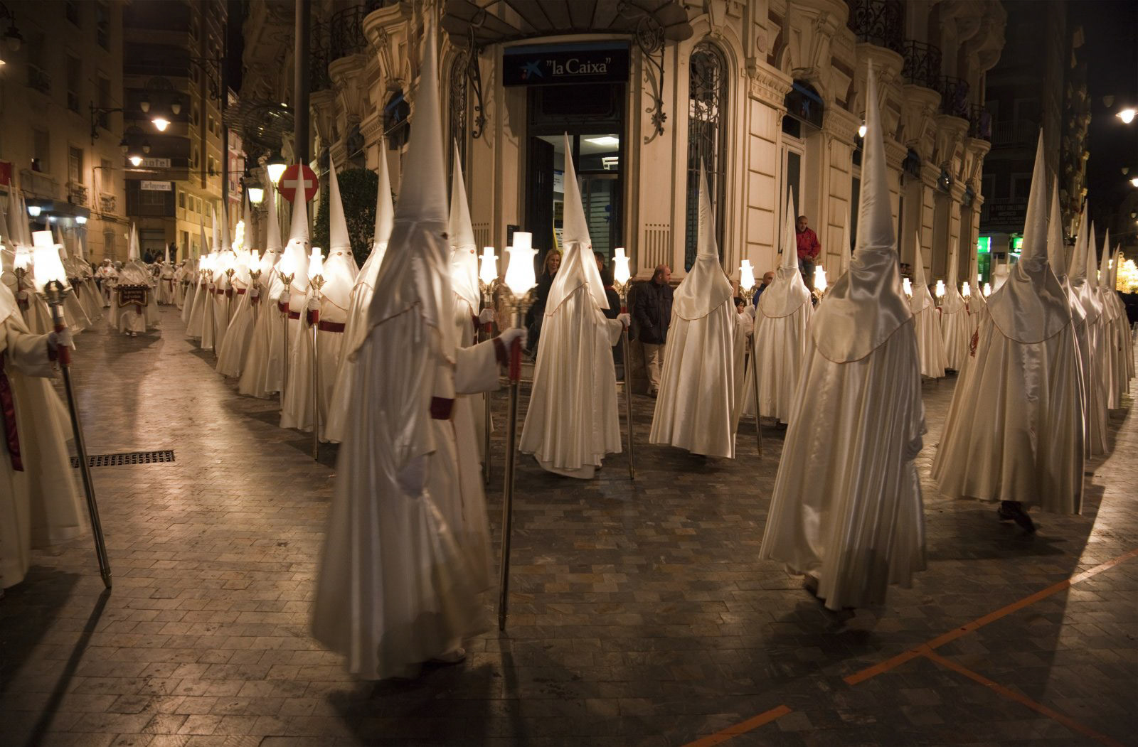 Nazarenos in a night time procession during Semana Santa (Holy Week) in Cartagena, Spain