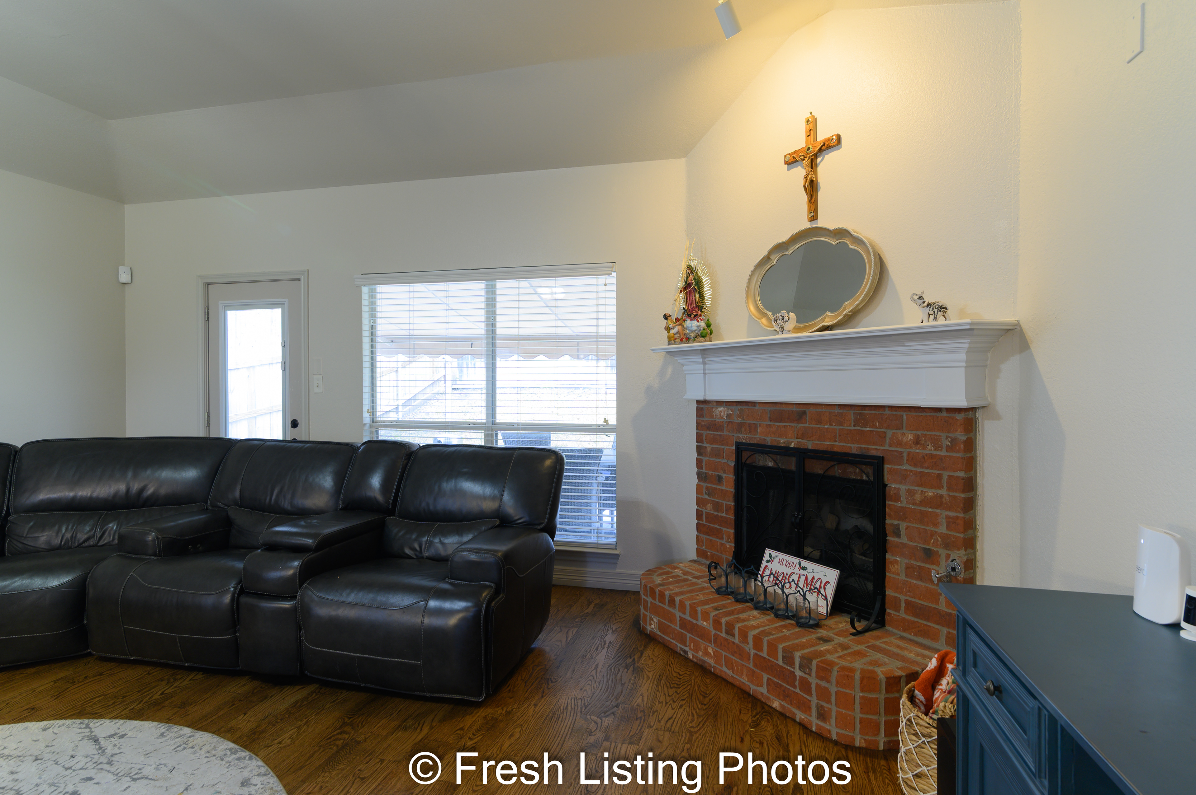 Living room with brick facade fireplace and patio view