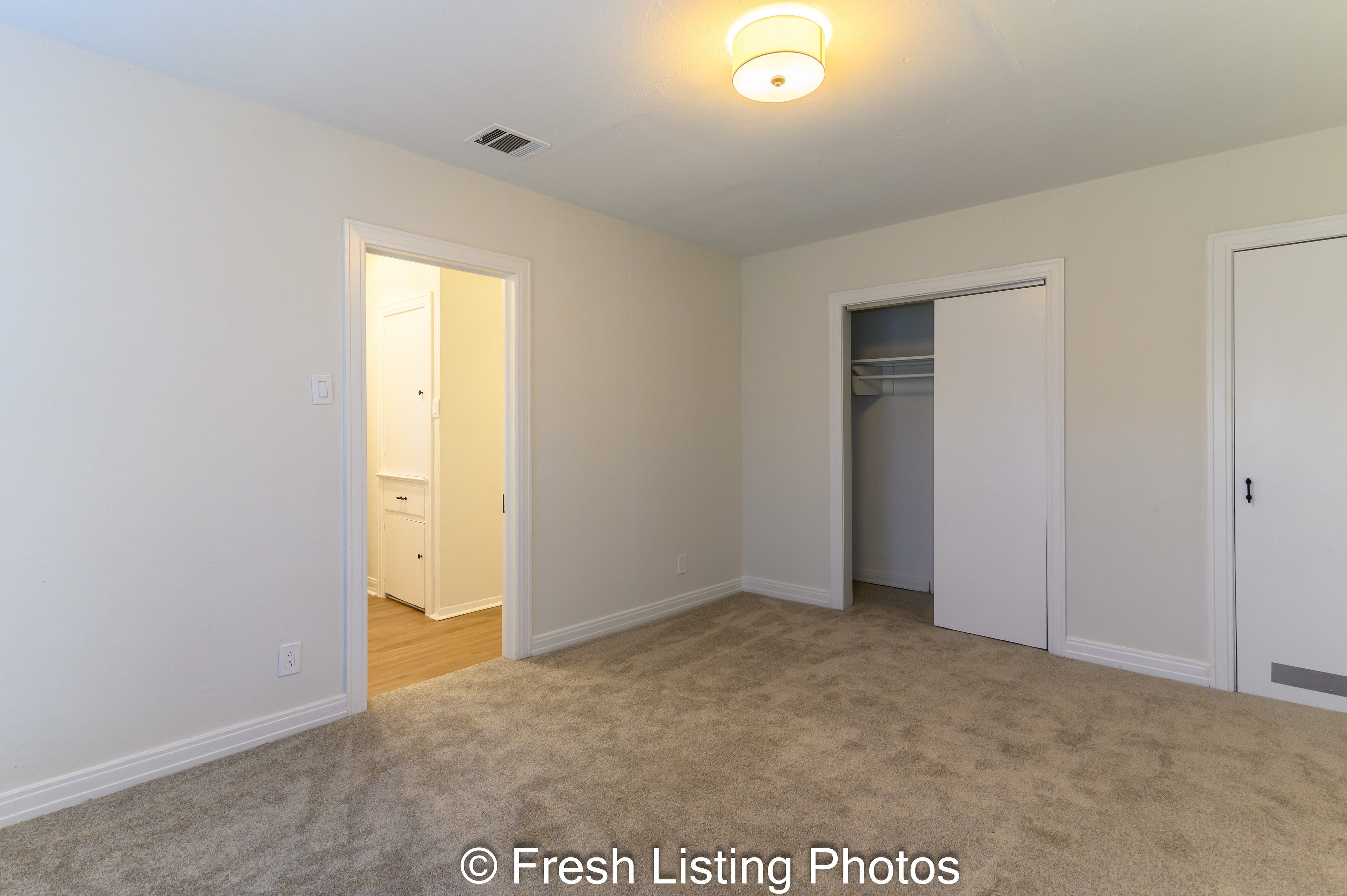 Bedroom with water heater closet and hallway view