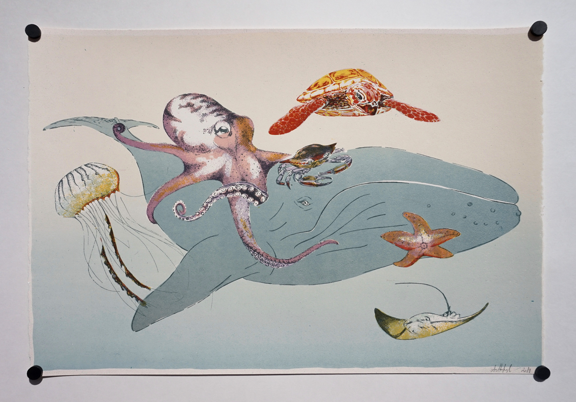 A large whale with creatures all around, an octopus, crab, starfish, jellyfish, stingray, and sea turtle all hand drawn and screen printed.