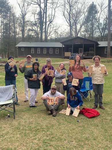 Retreat participants holding up broken boards in a group photo