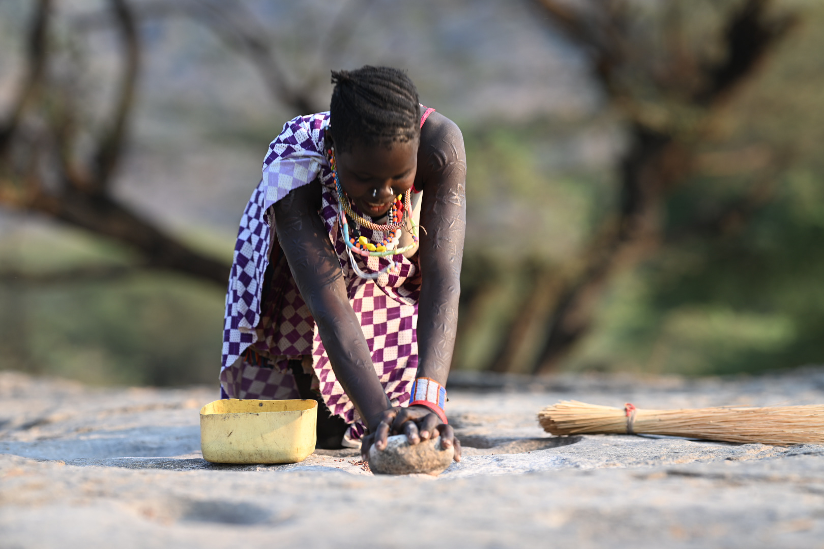 Hand grinding sorghum - all the villages ground grains this way