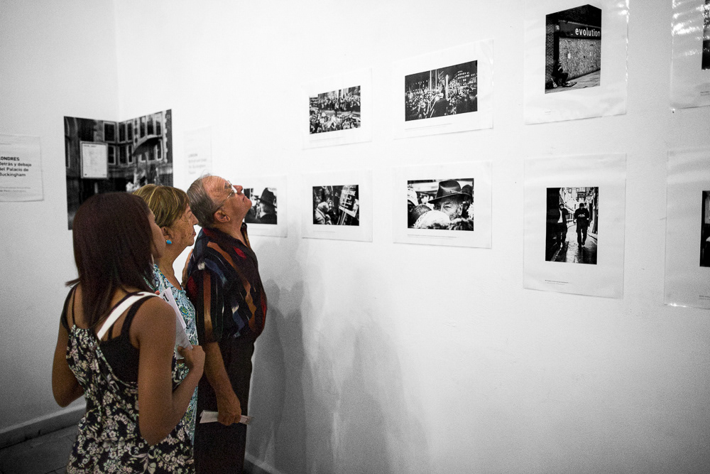 Picture of the frames on the exhibition wall with the caption and also Gallery Attendants at "Londres. Detrás y debajo del palacio de buckingam" exhibition space. gallery arte soy in santiago de cuba, cuba. 2015 © Pedro Rodrigues