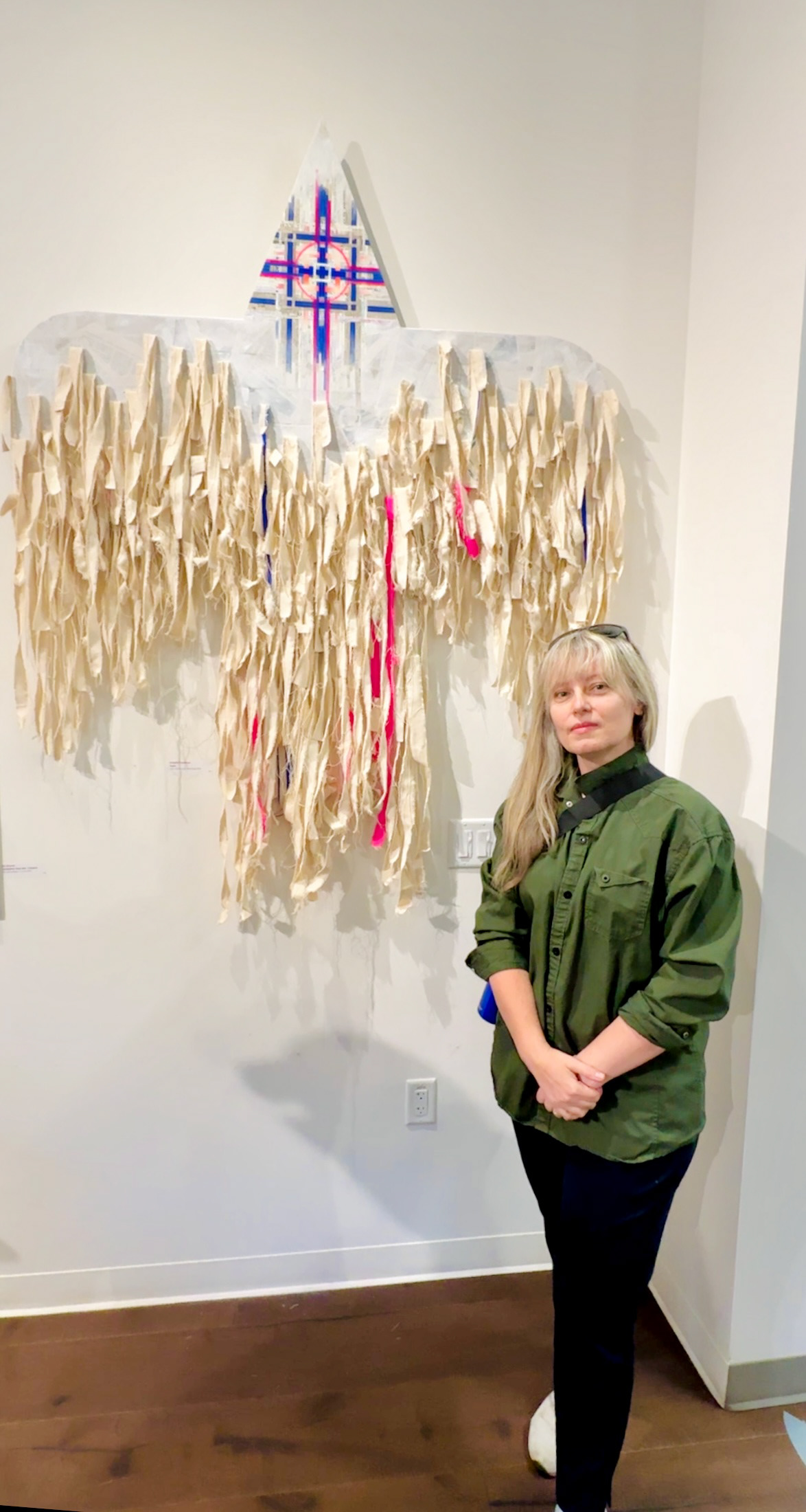 Artist Natasha Kramskaya is standing next to her large work, Karuna, at Works gallery, 2025