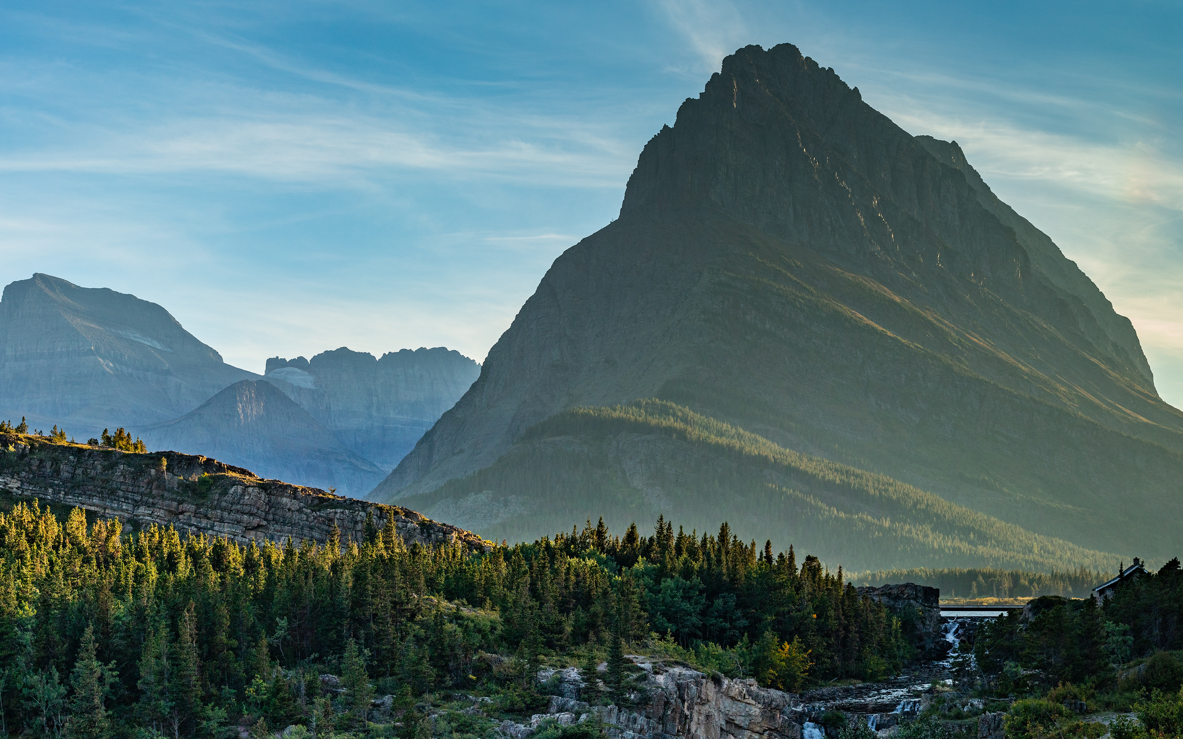 Photograph of Swiftcurrent Falls in Glacier National Park, with Mount Grinnell rising behind the waterfall