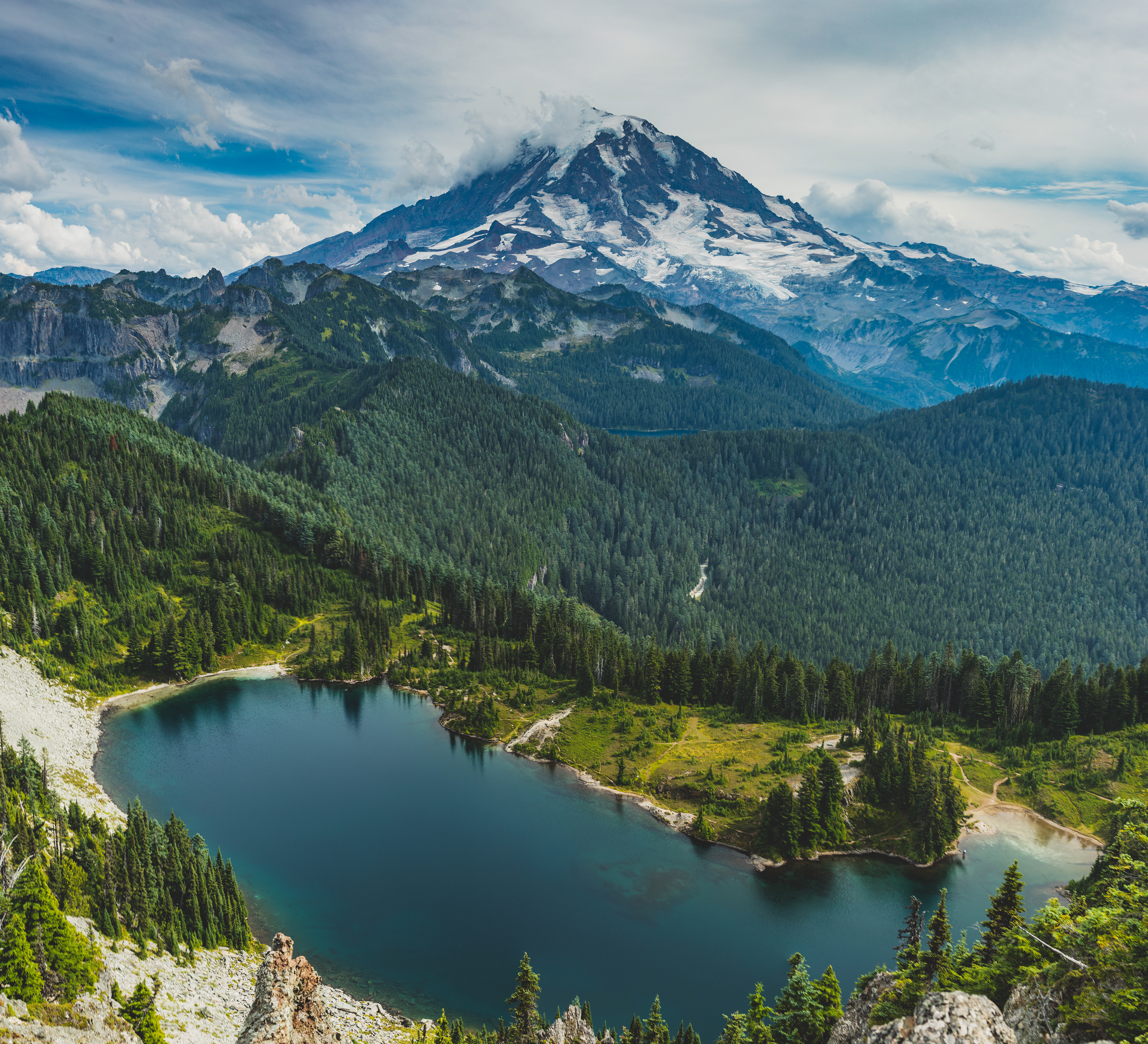 Photograph of Eunice Lake and Mount Rainier viewed from Tolmie Peak in Mount Rainier National Park, Washington, with alpine water, forested slopes, and a prominent volcanic peak.