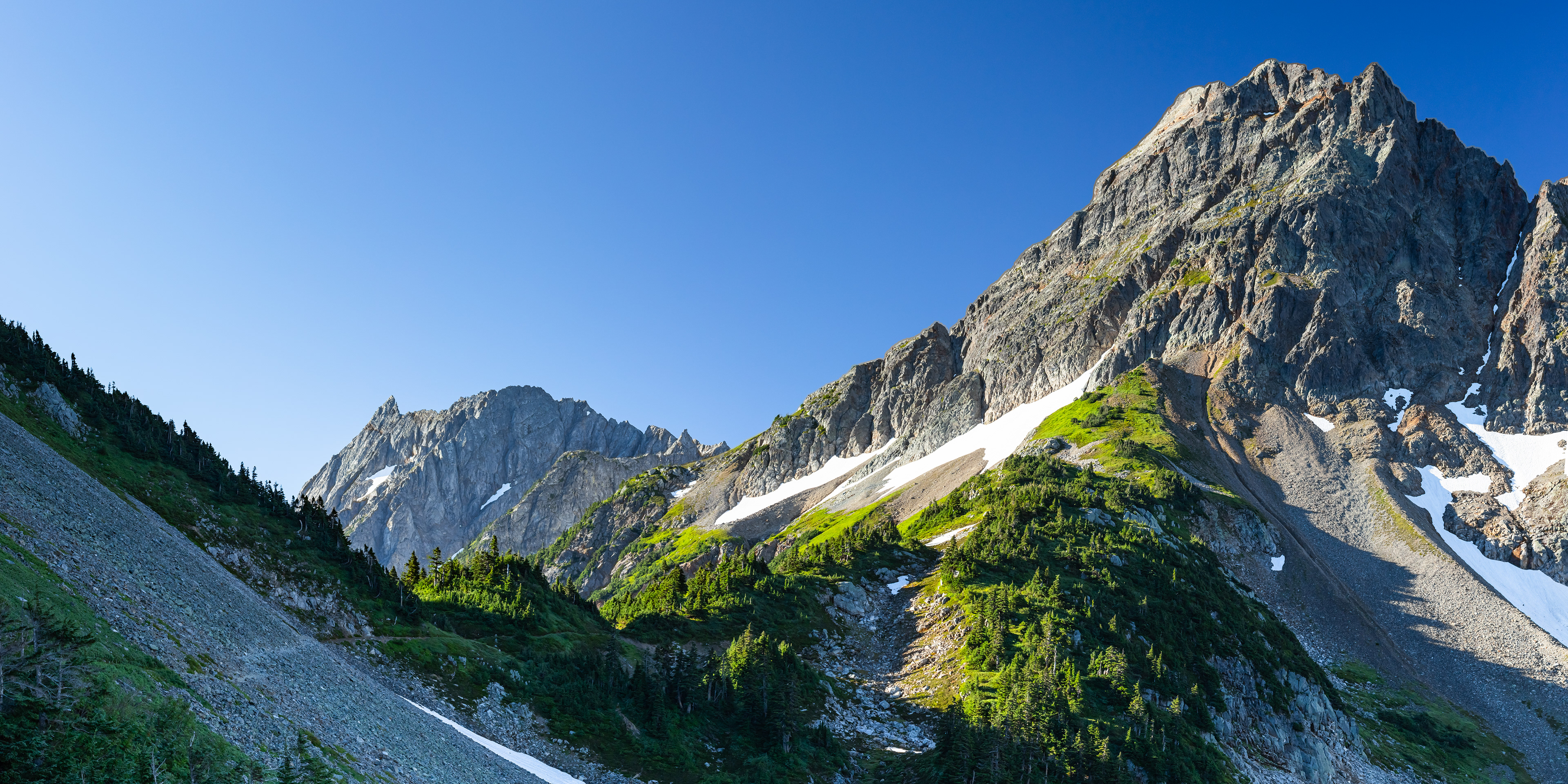Photograph of Cascade Pass in North Cascades National Park, Washington, with alpine meadows, surrounding peaks, and high mountain terrain.