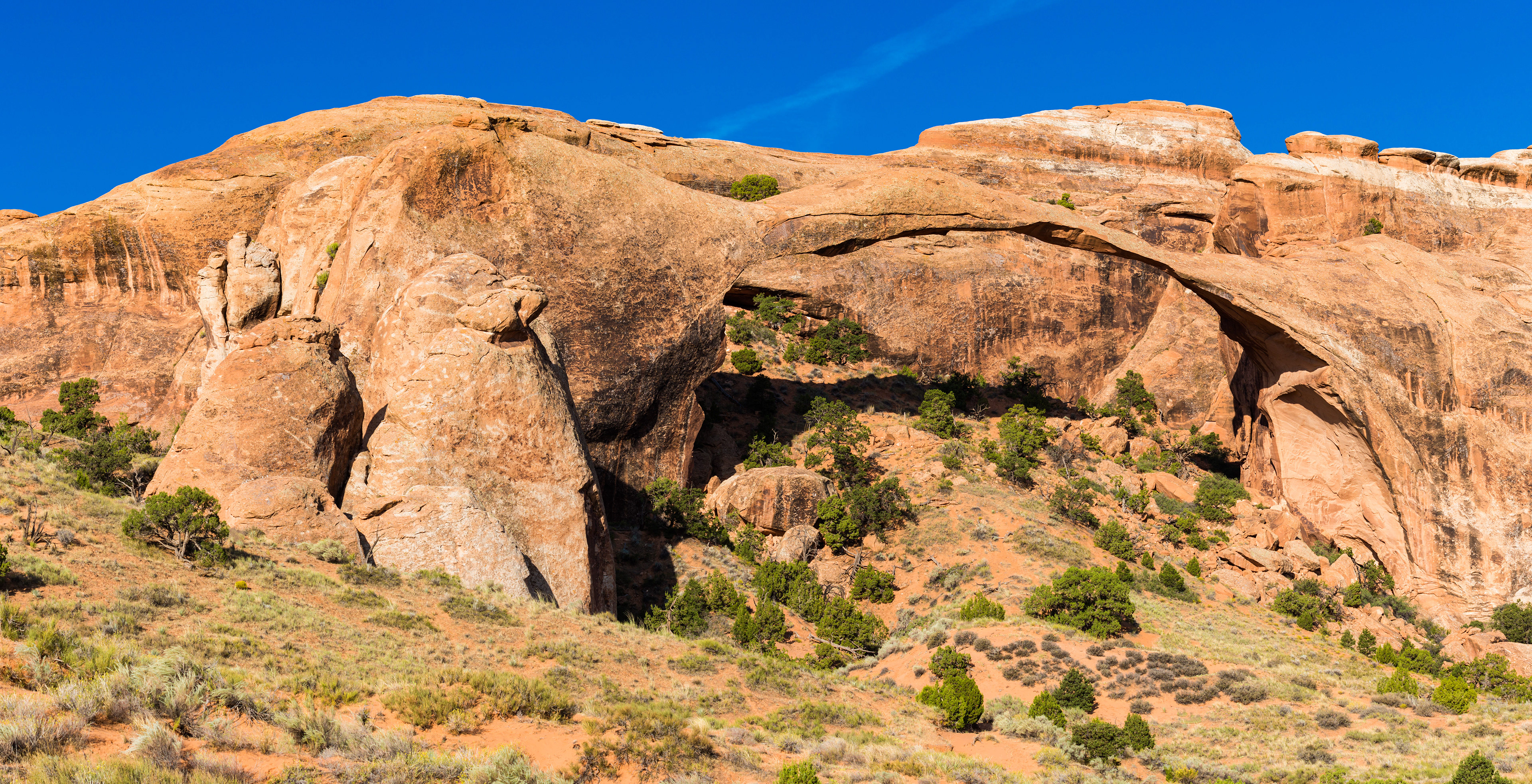 Photograph of Landscape Arch in Arches National Park, Utah, featuring a long natural sandstone arch spanning a narrow desert canyon.