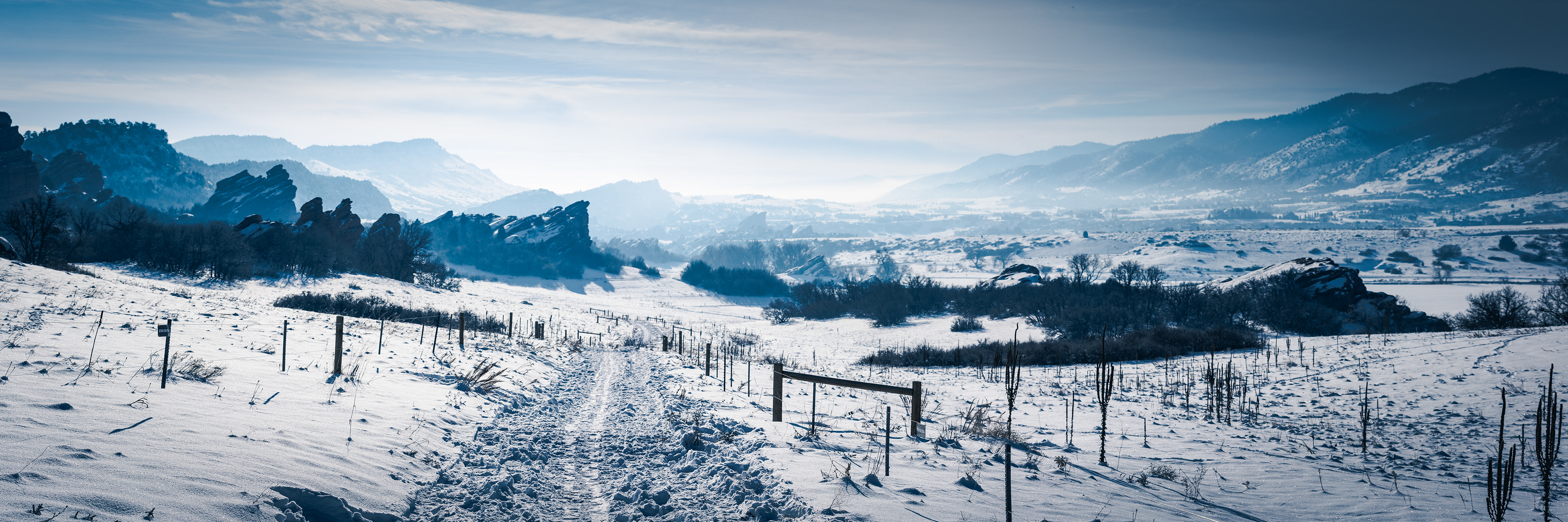Photograph of Roxborough State Park in winter in Colorado, with snow-covered red rock formations, open trails, and foothills terrain.