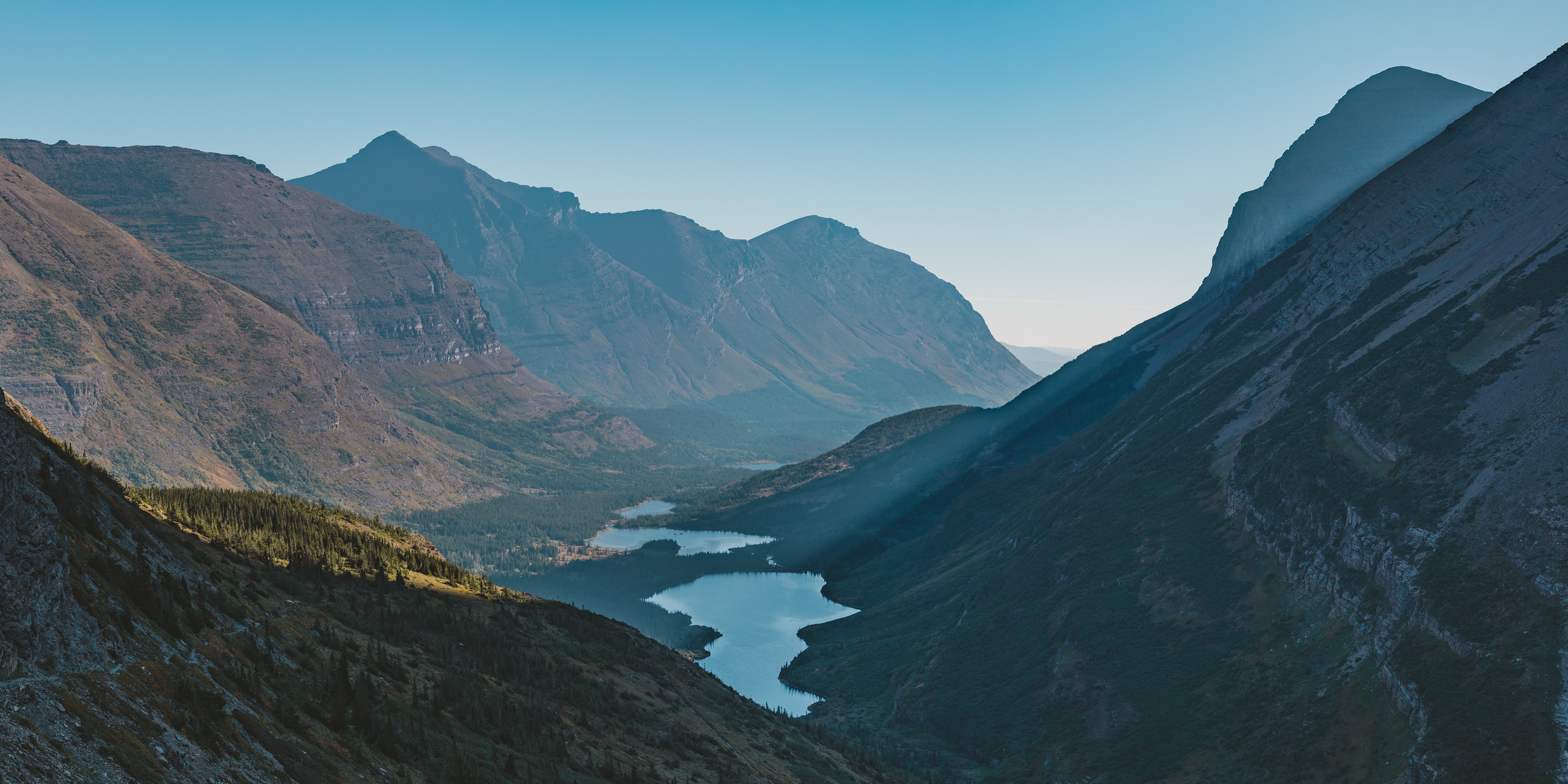 Photograph of Bullhead Lake seen from the Swiftcurrent Pass Trail in Glacier National Park, surrounded by alpine terrain and mountain ridges