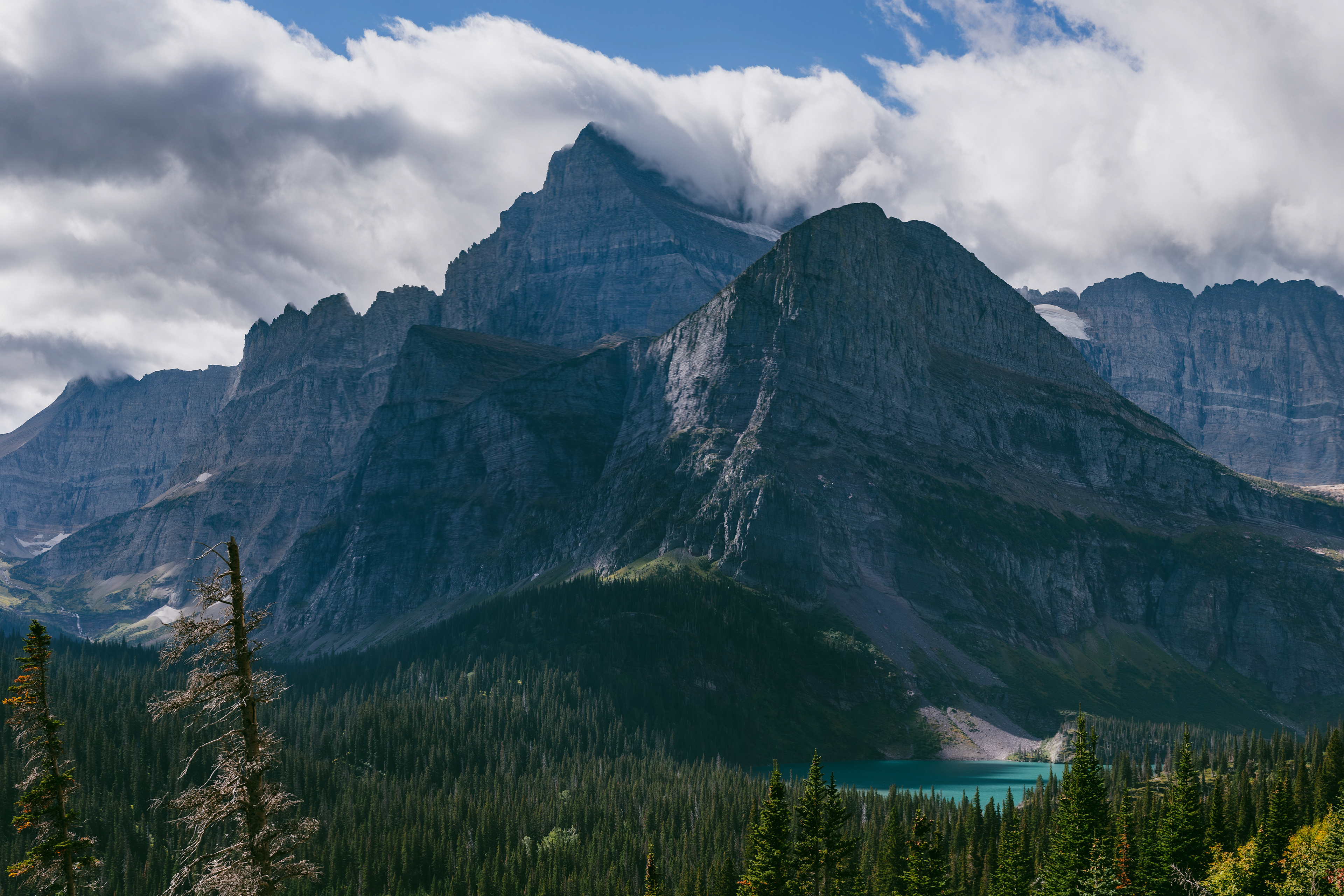 Photograph of Grinnell Lake and Angel Wing in Glacier National Park, Montana, with turquoise alpine water, steep rock walls, and surrounding mountain terrain.