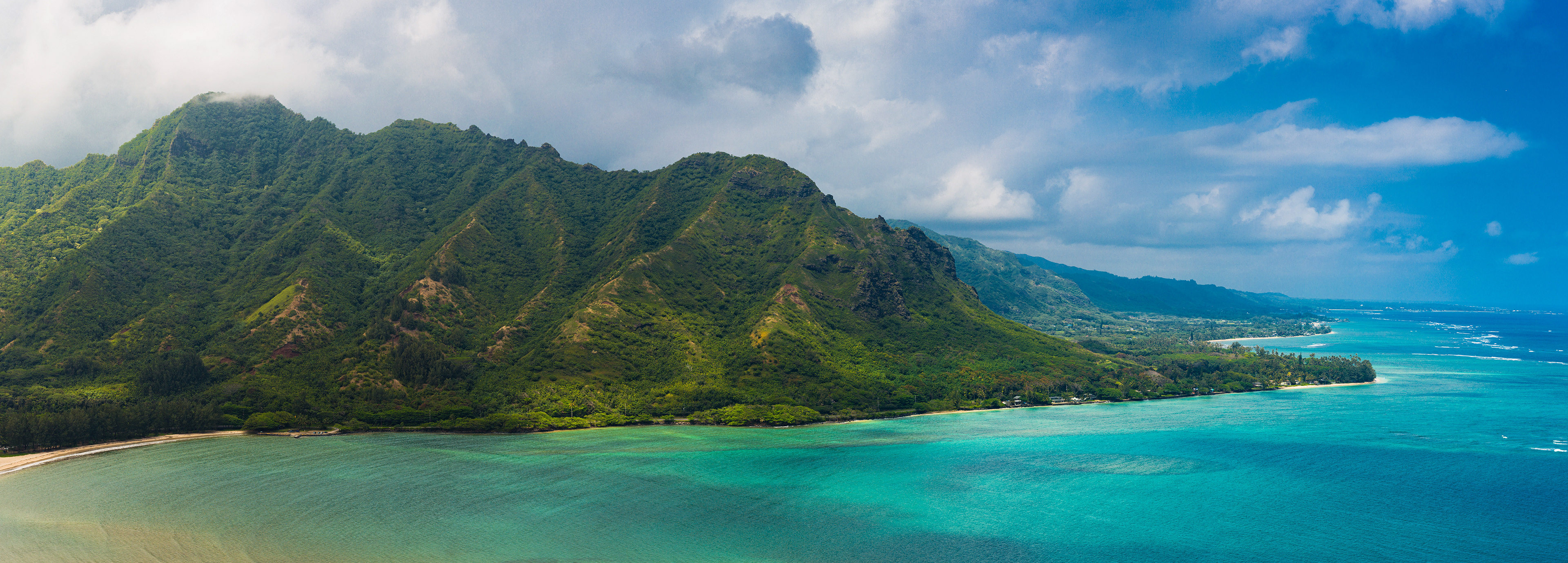 Photograph of Huilua Pond on Oahu, Hawaii, with calm water, surrounding vegetation, and tropical landscape.