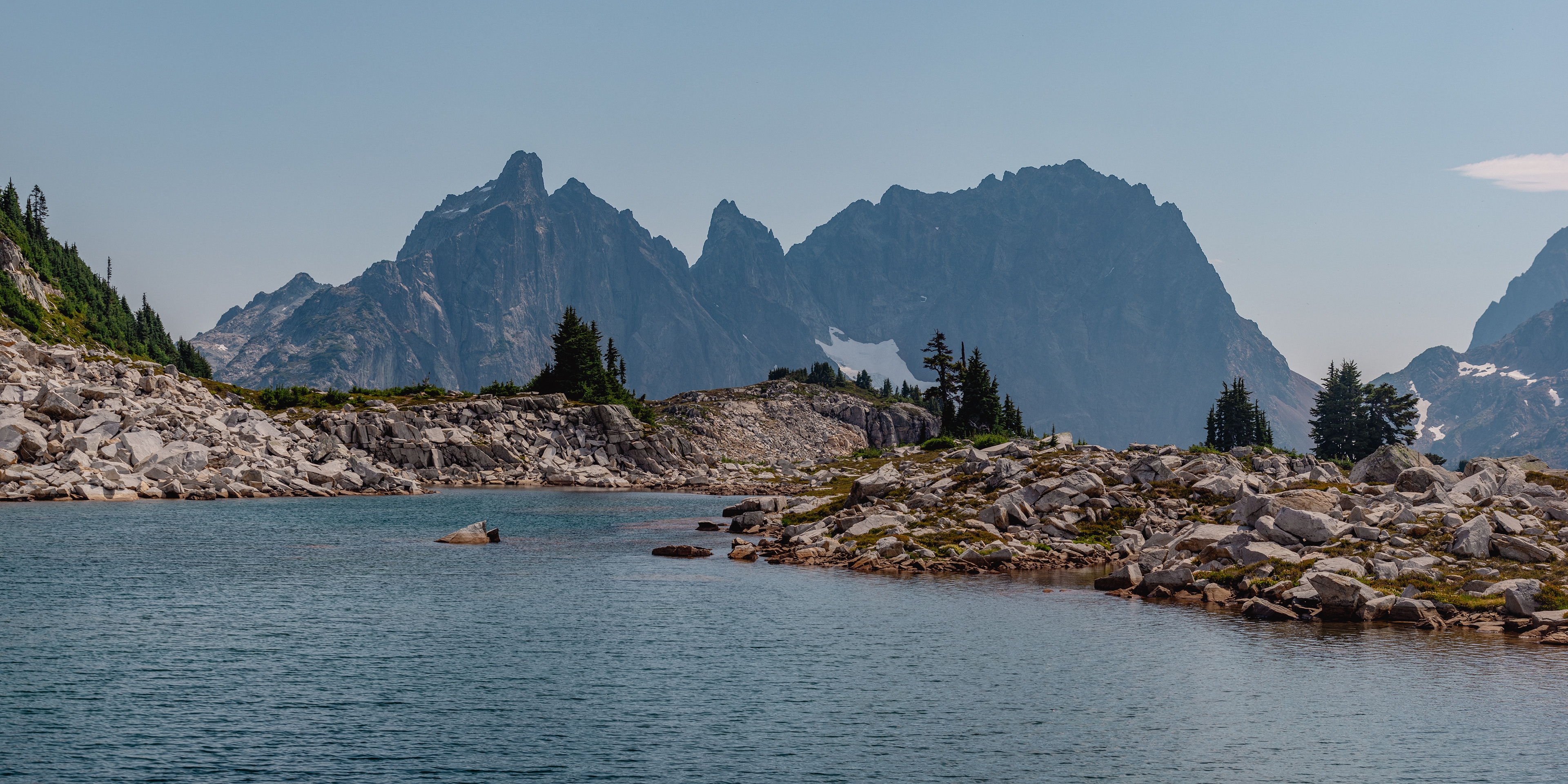 Photograph of Tank Lakes in the Mount Baker-Snoqualmie National Forest, Washington, featuring clear alpine lakes surrounded by rocky basins, evergreen forest, and rugged mountain terrain