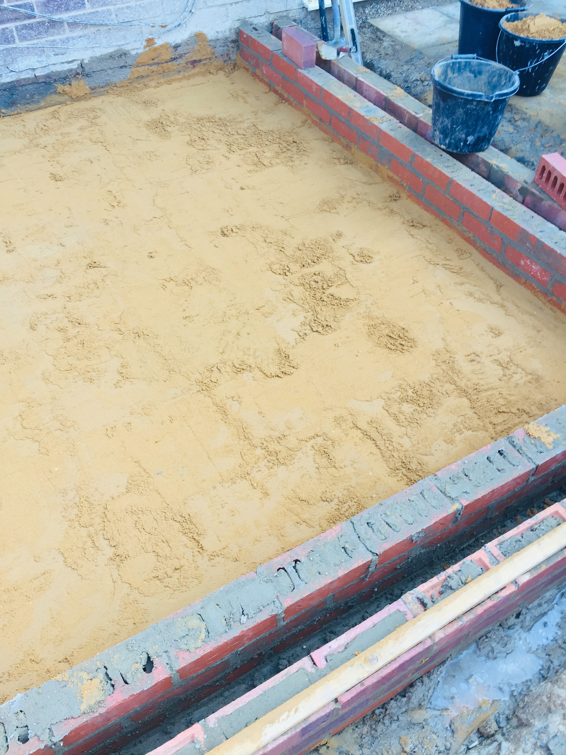 A level layer of sand is laid before insulation is applied.