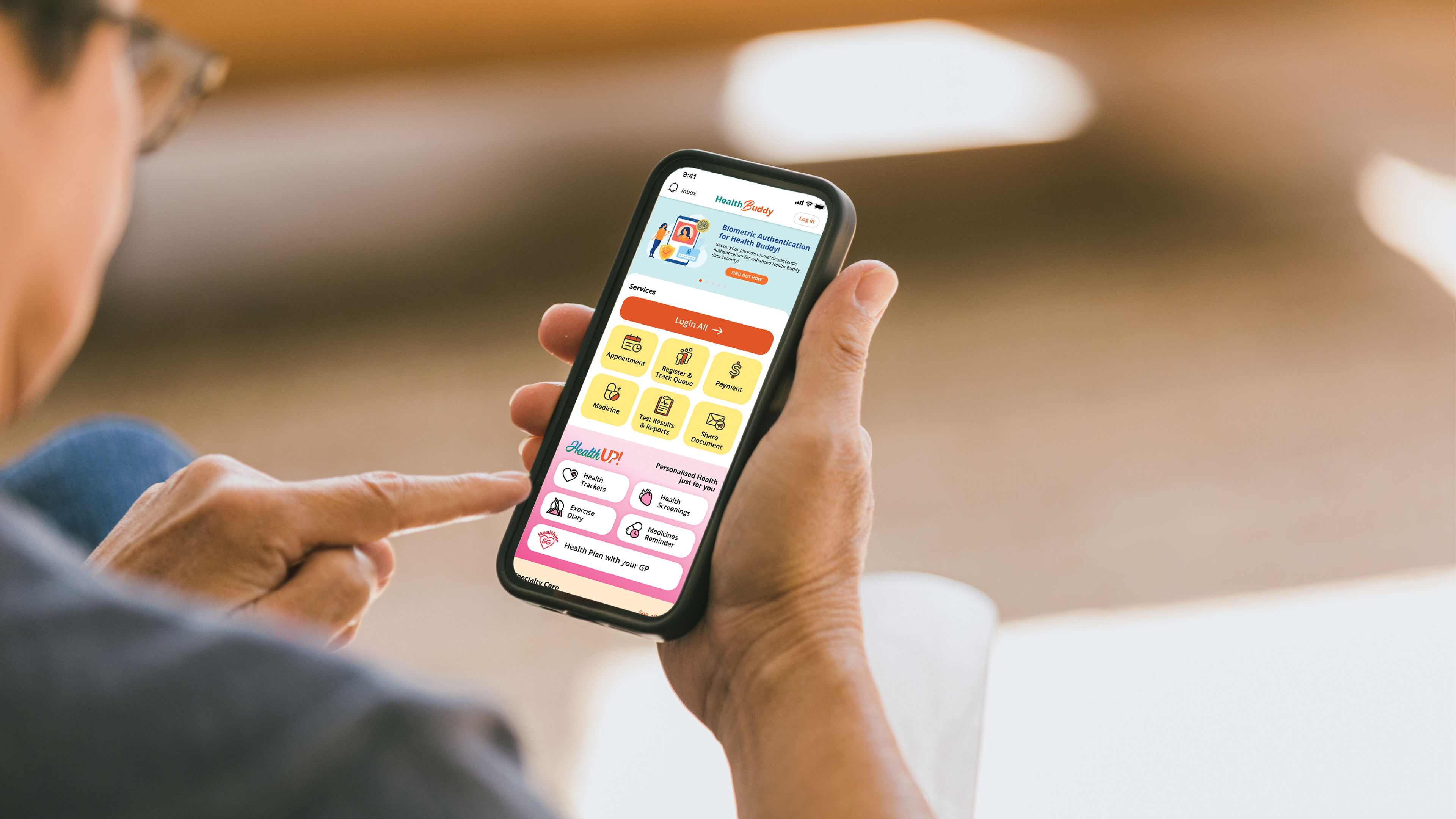 Senior holding a phone showing Health Buddy Home screen interface
