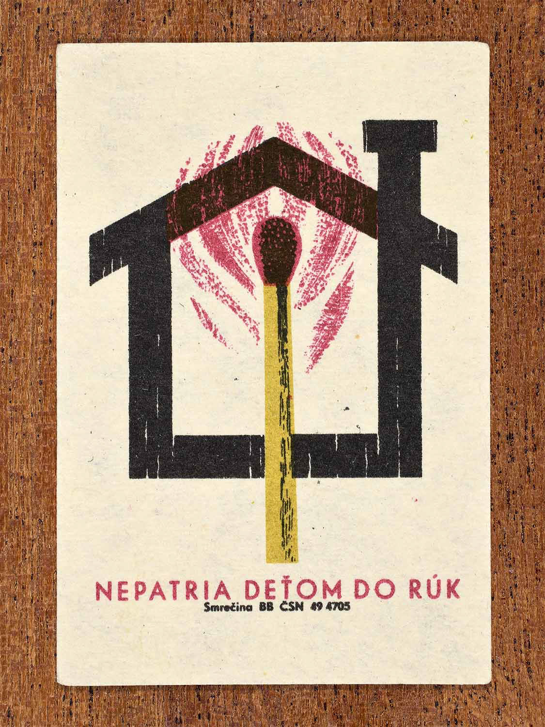 Vintage 1964 Czechoslovak matchbox label showing a lit match inside a house shape in red, black and yellow colours. Produced by the Smrečina match factory to warn that matches do not belong in children’s hands.