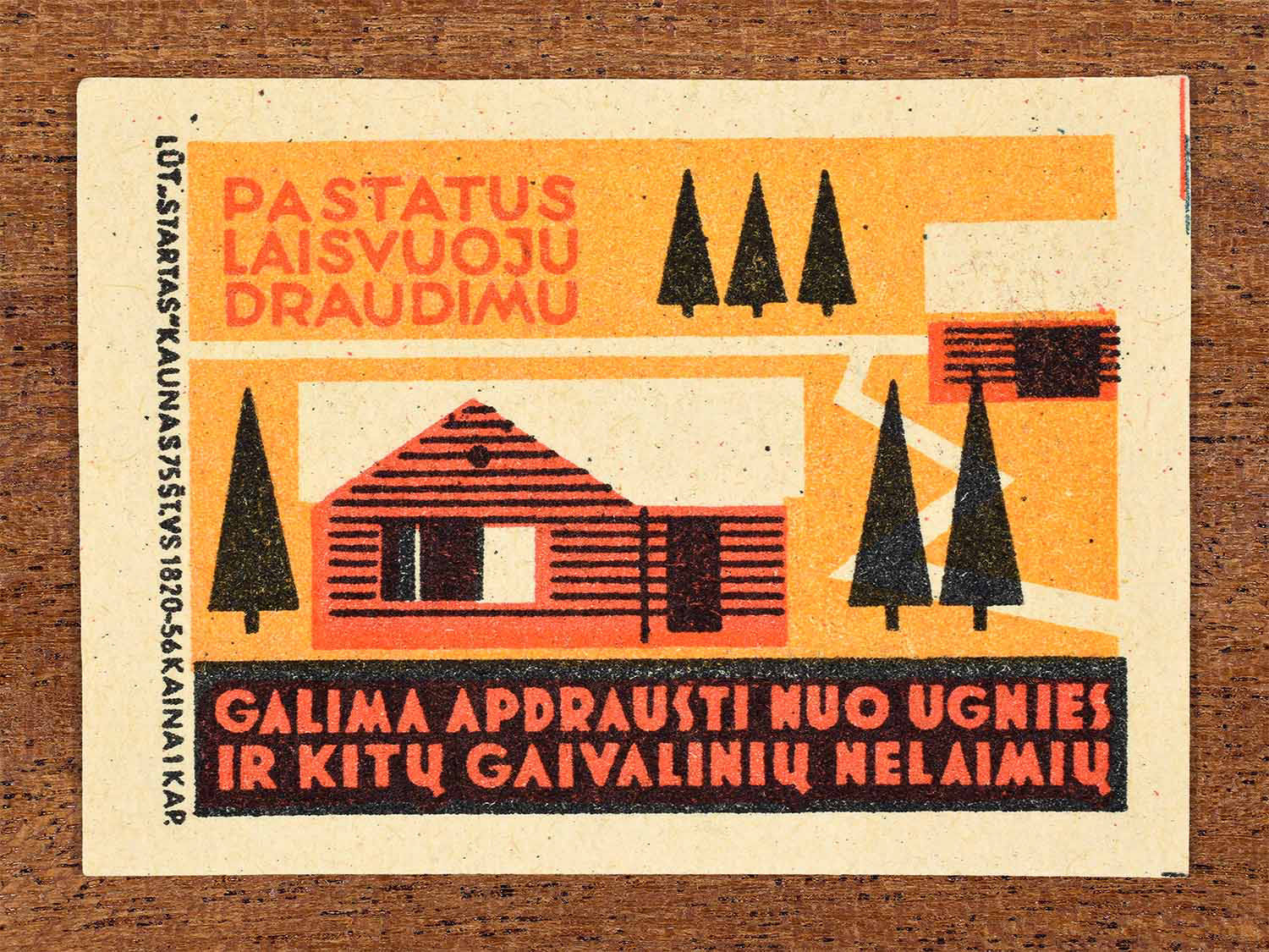 Vintage 1963 Lithuanian matchbox label showing a house surrounded by trees in red, orange and black colours. Produced by the Startas Kaunas match factory to promote fire and disaster insurance for homes.