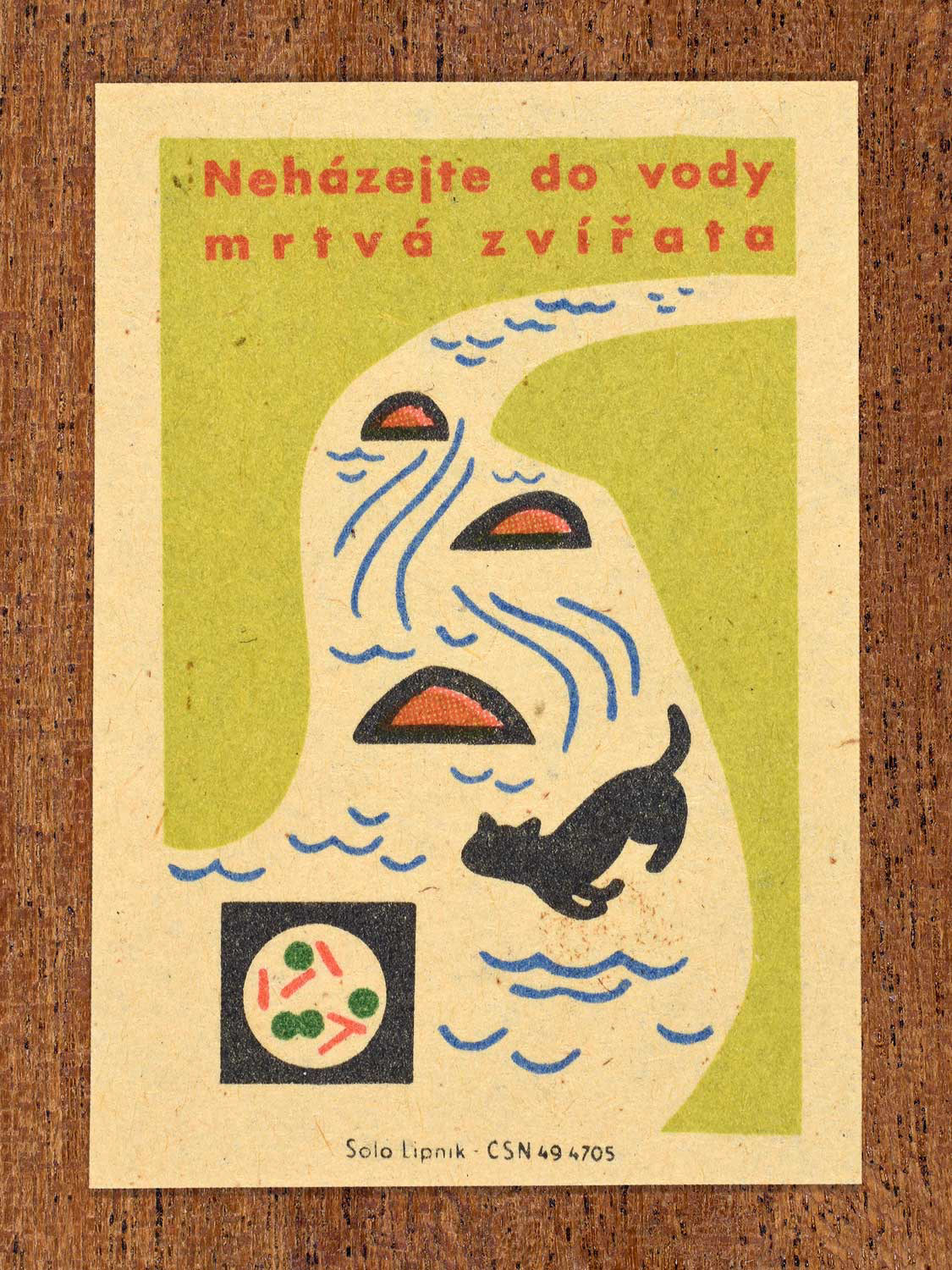Vintage c. 1963 Czech matchbox label showing a river carrying dead animals and contamination symbols, in green, red and black colours. Produced by Solo Lipník match factory warning against throwing animal carcasses into water.