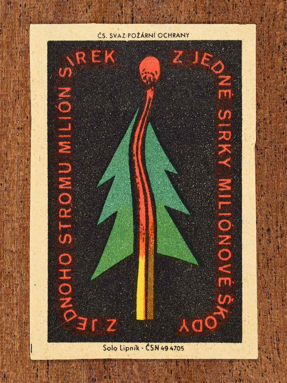 Vintage c. 1961 Czech matchbox label showing a burning match transforming into a tree in red, green, and yellow colours. Produced by the Solo Lipník match factory to warn that one match can cause damage worth millions.